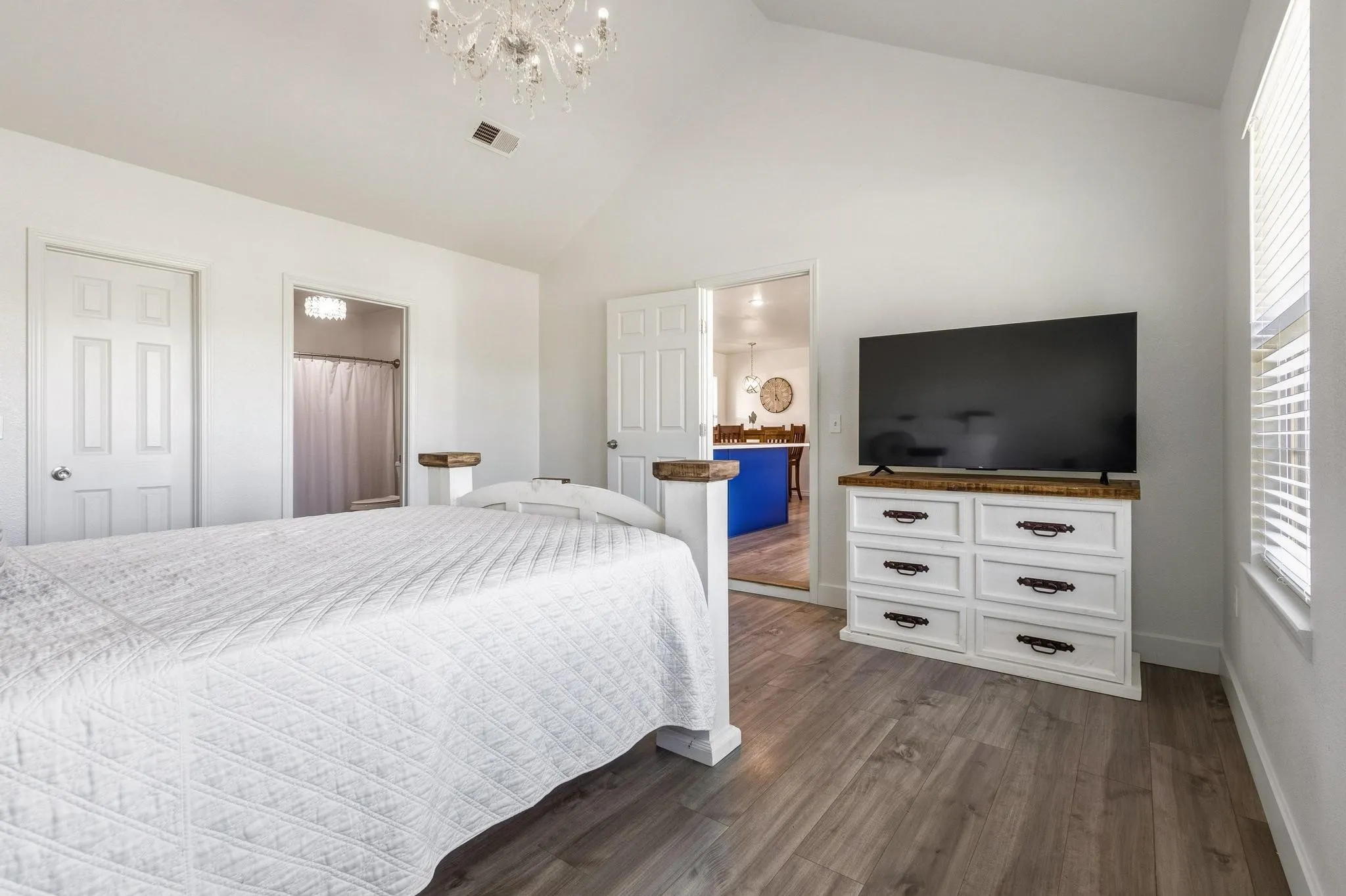 Bedroom featuring dark wood finished floors, a high ceiling, and hanging lights