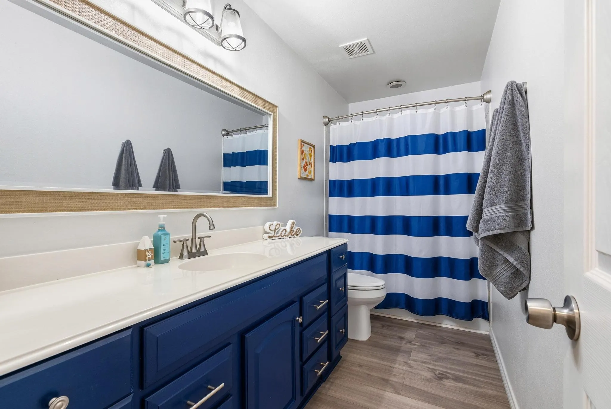 Bathroom with vanity, a shower with curtain, and dark wood finished floors