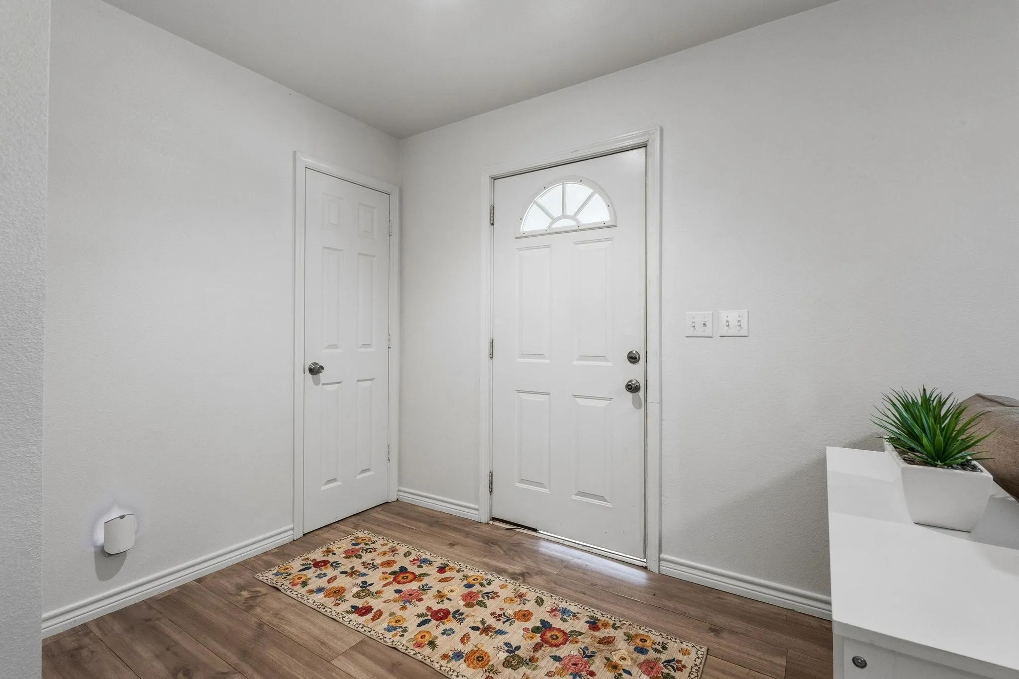 Foyer with baseboards and wood finished floors