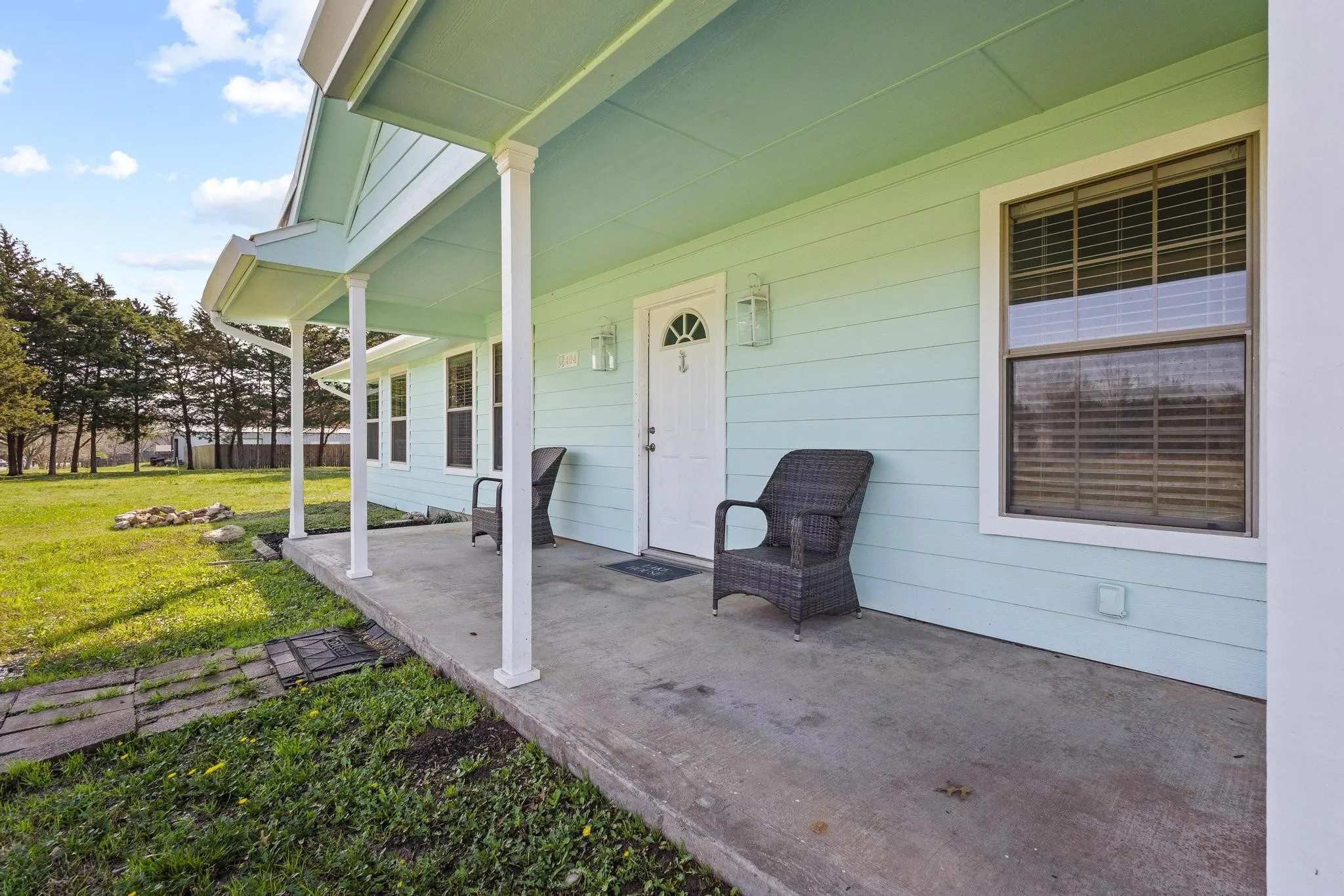 Property entrance with a lawn and covered porch