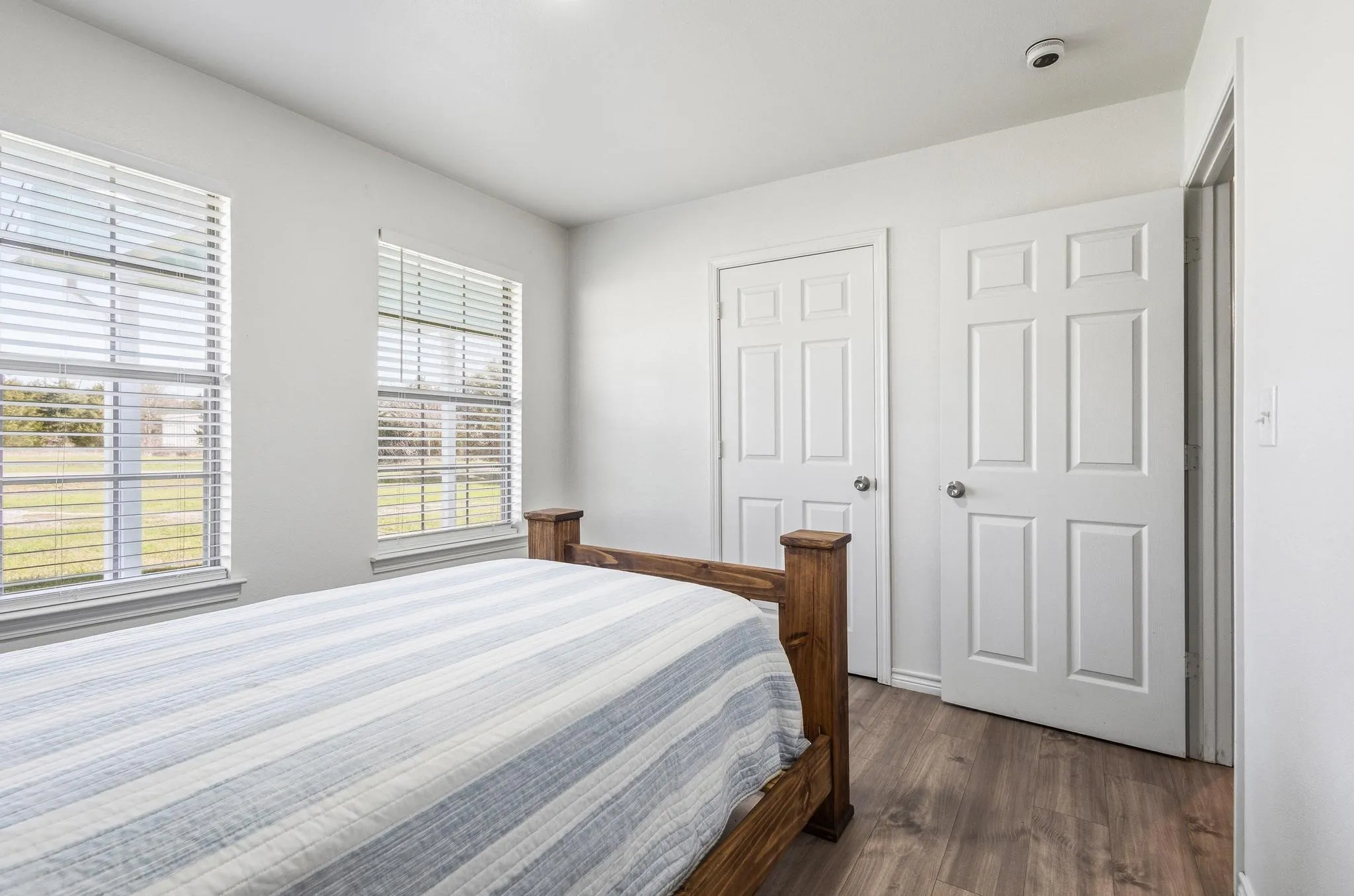 Bedroom with dark wood-type flooring and baseboards