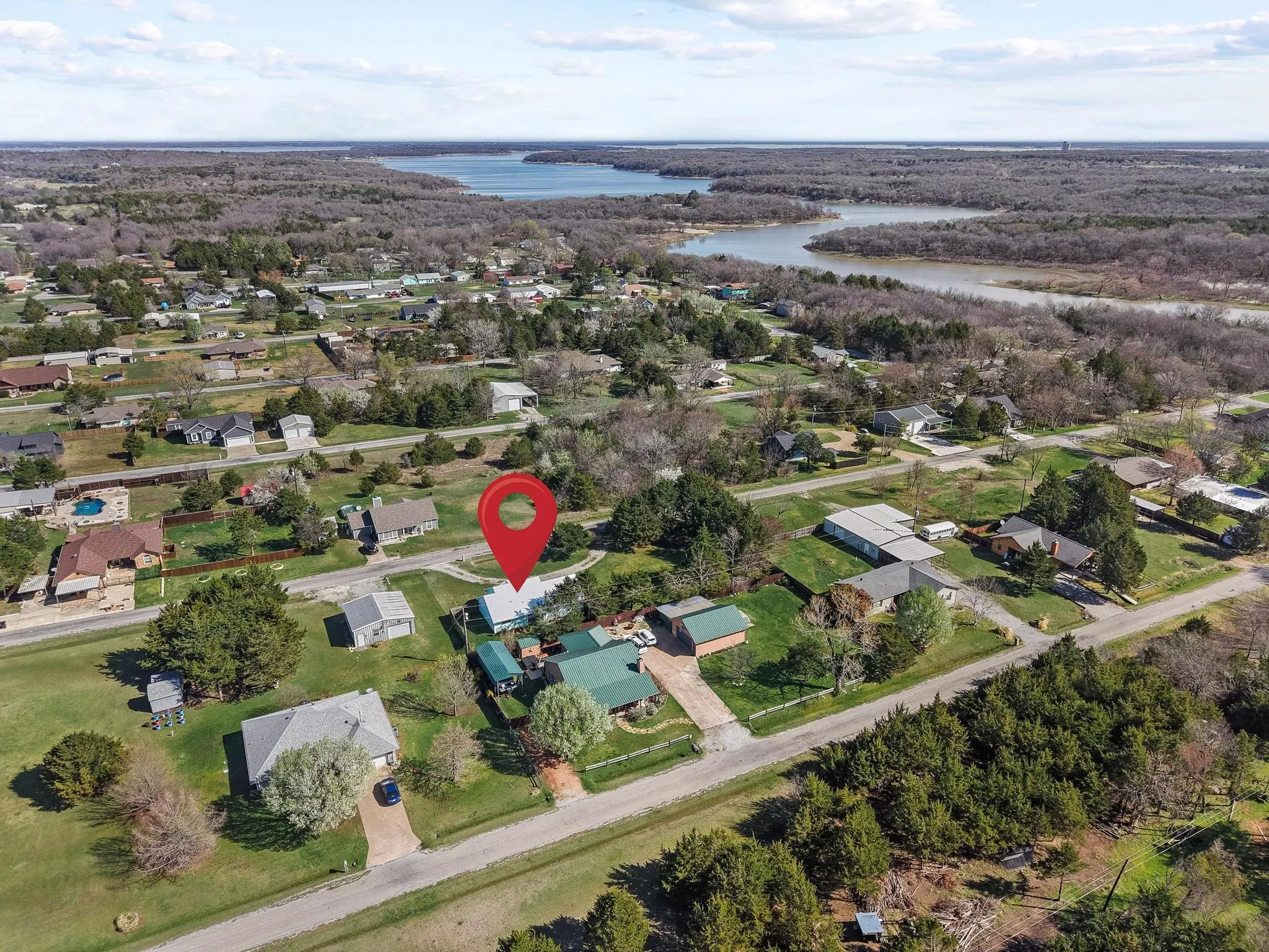 Aerial view of property and surrounding area featuring nearby suburban area and a nearby body of water