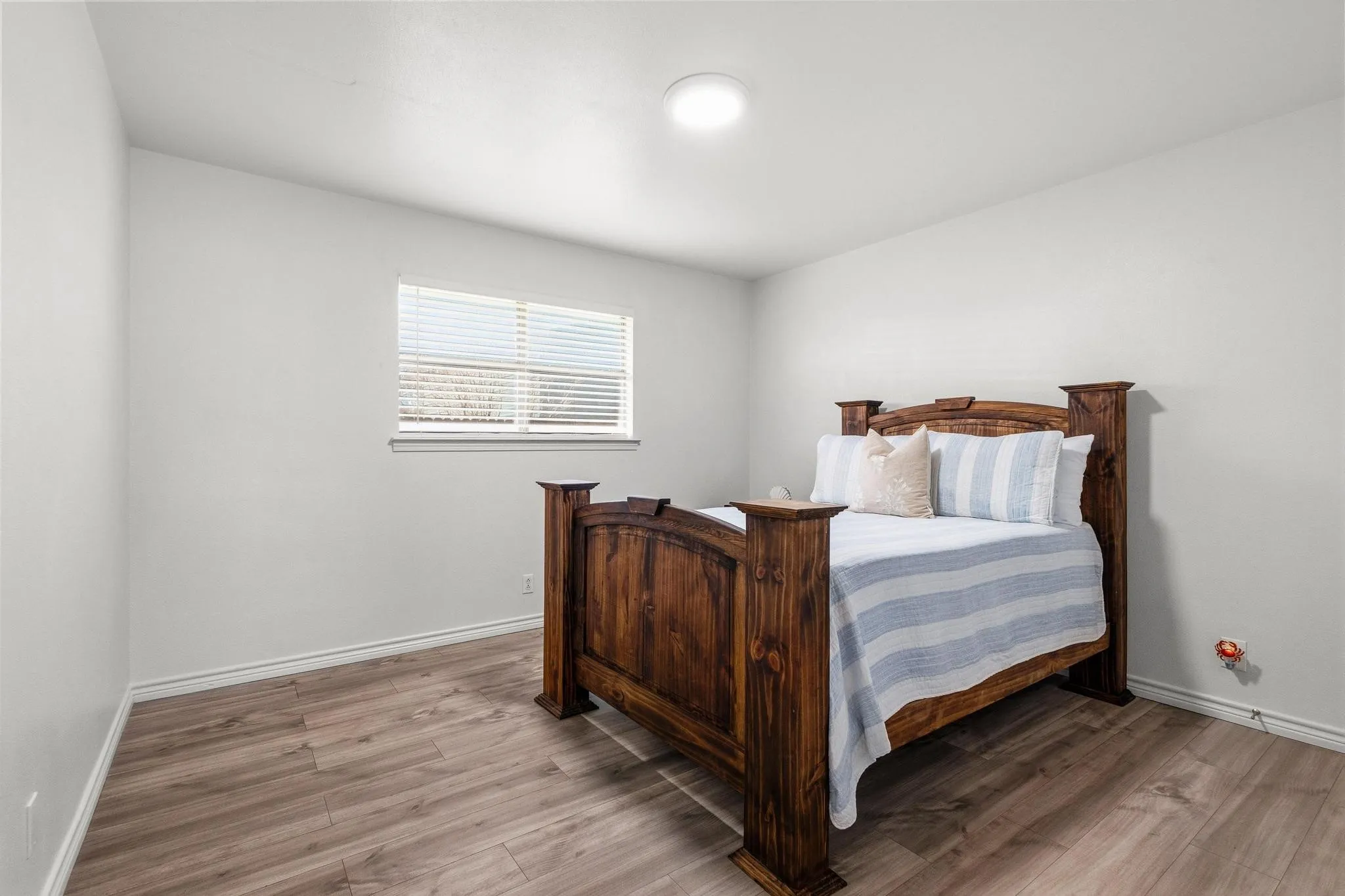 Bedroom with light wood-type flooring and baseboards