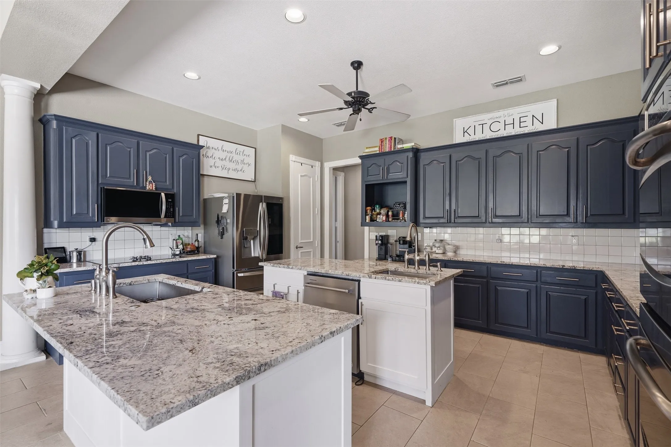 Kitchen featuring two islands with stone countertops, blue cabinetry, tile flooring, and recessed lighting