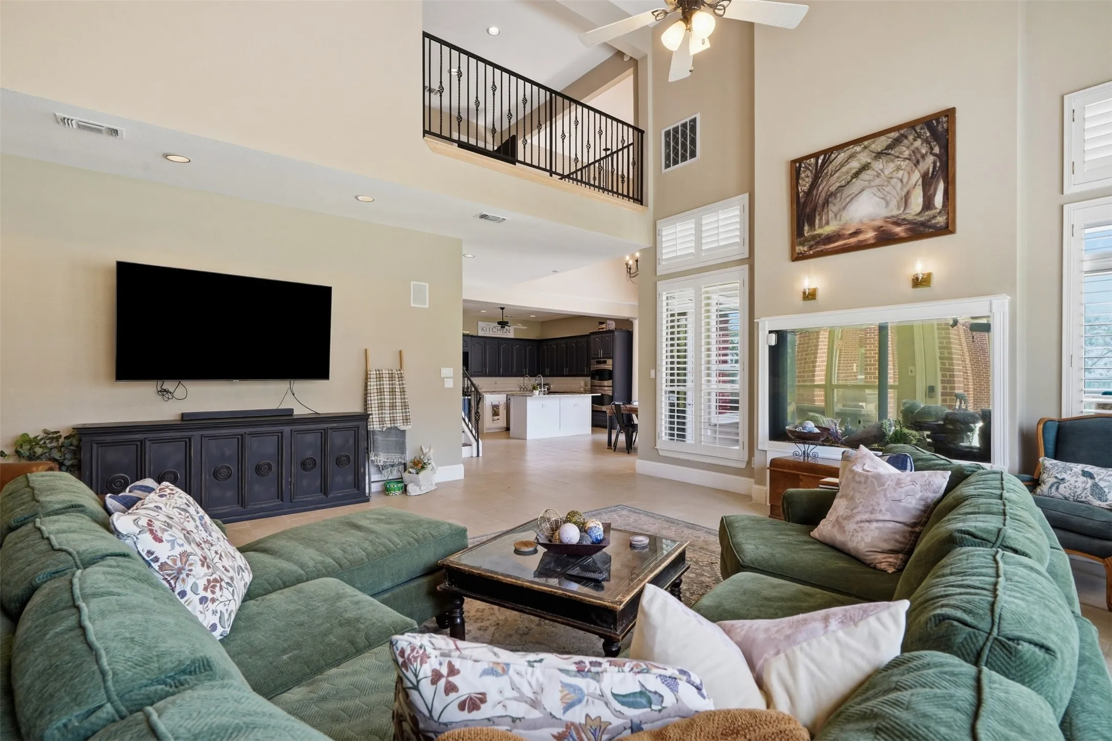 Two-story living area featuring a vaulted ceiling and an upper-level balcony with iron balusters