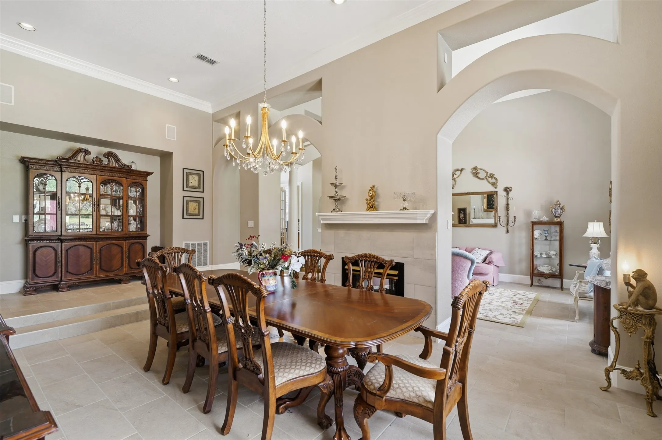 Dining area featuring tile flooring, a tiered ceiling, and an ornate chandelier