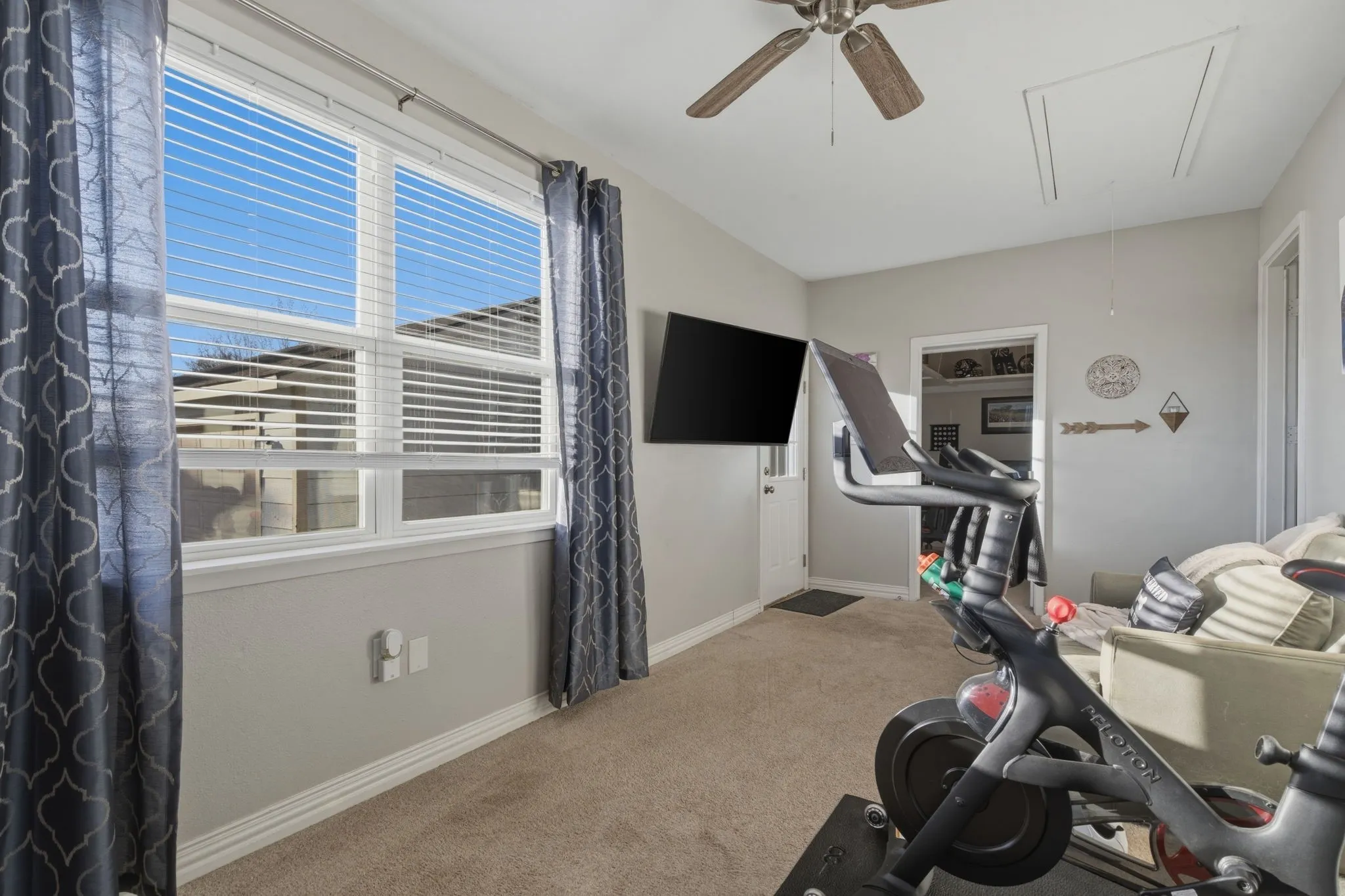 Exercise area featuring light colored carpet and a ceiling fan