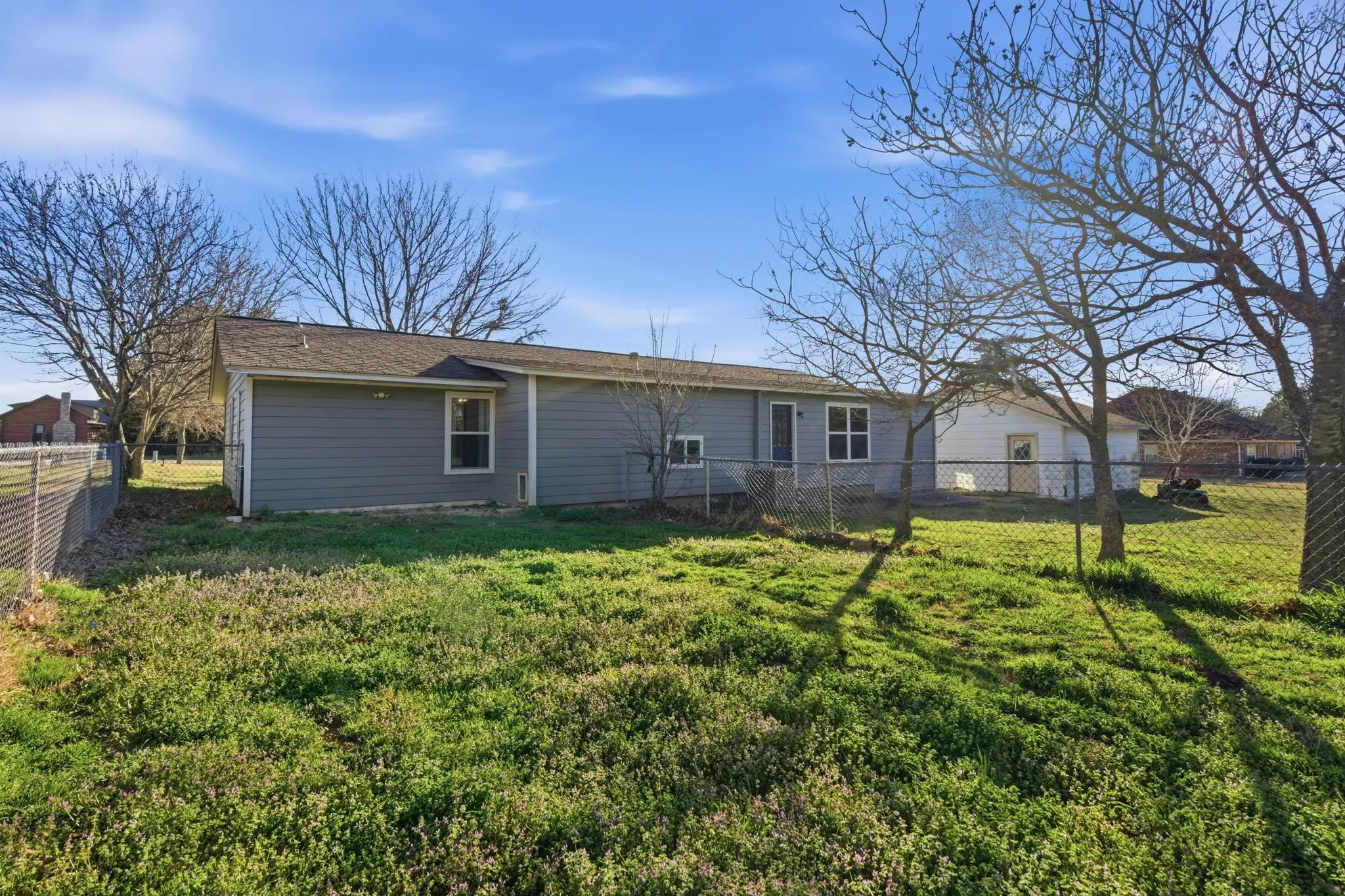 Rear view of property with a fenced backyard