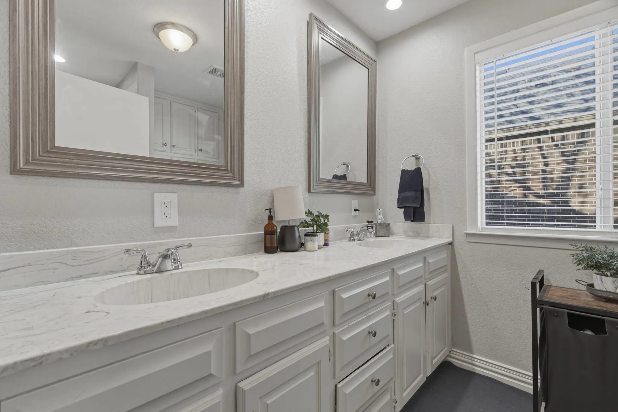 Bathroom with a textured wall and double vanity