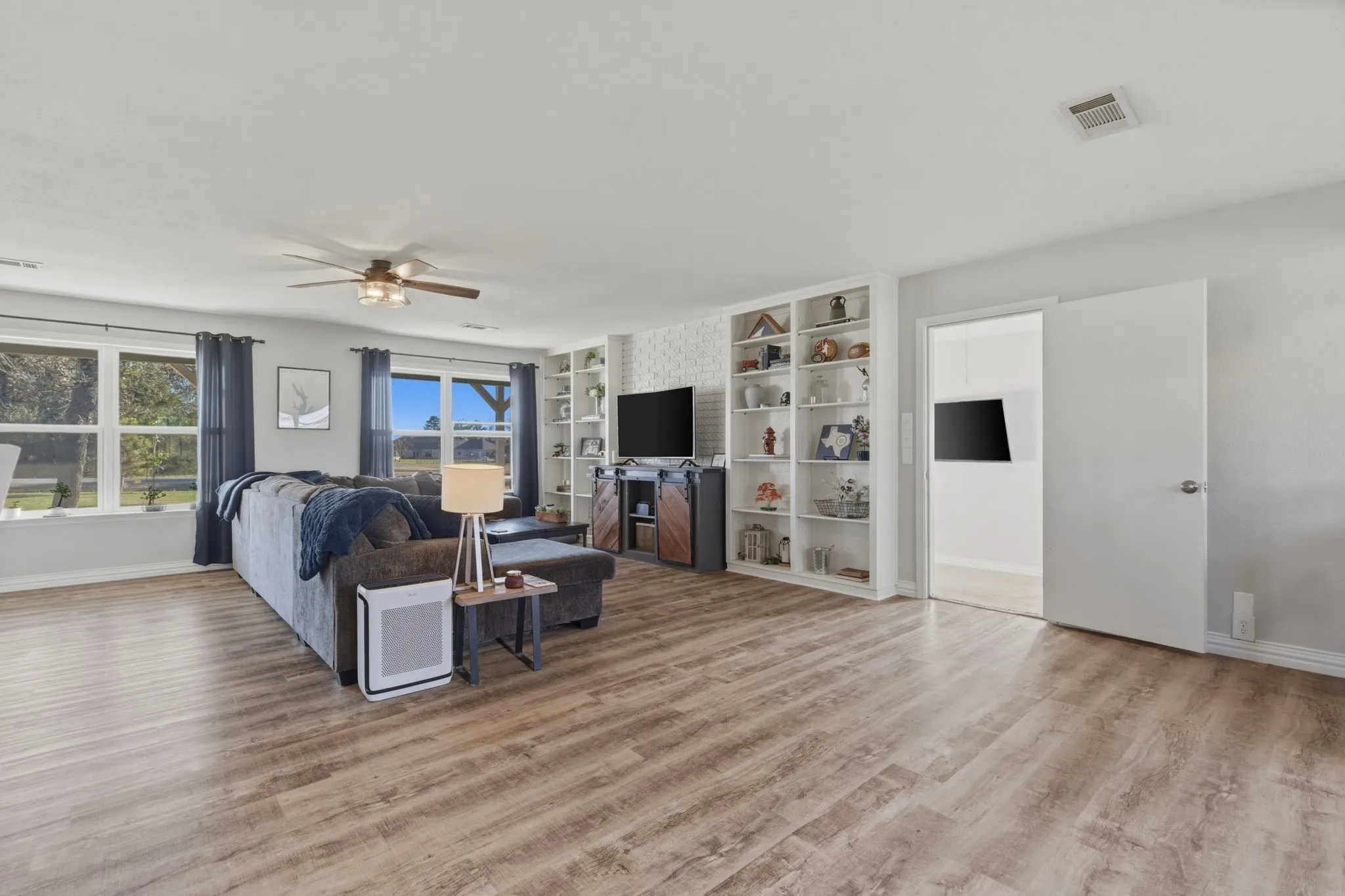 Living room featuring built in features, ceiling fan, and wood finished floors