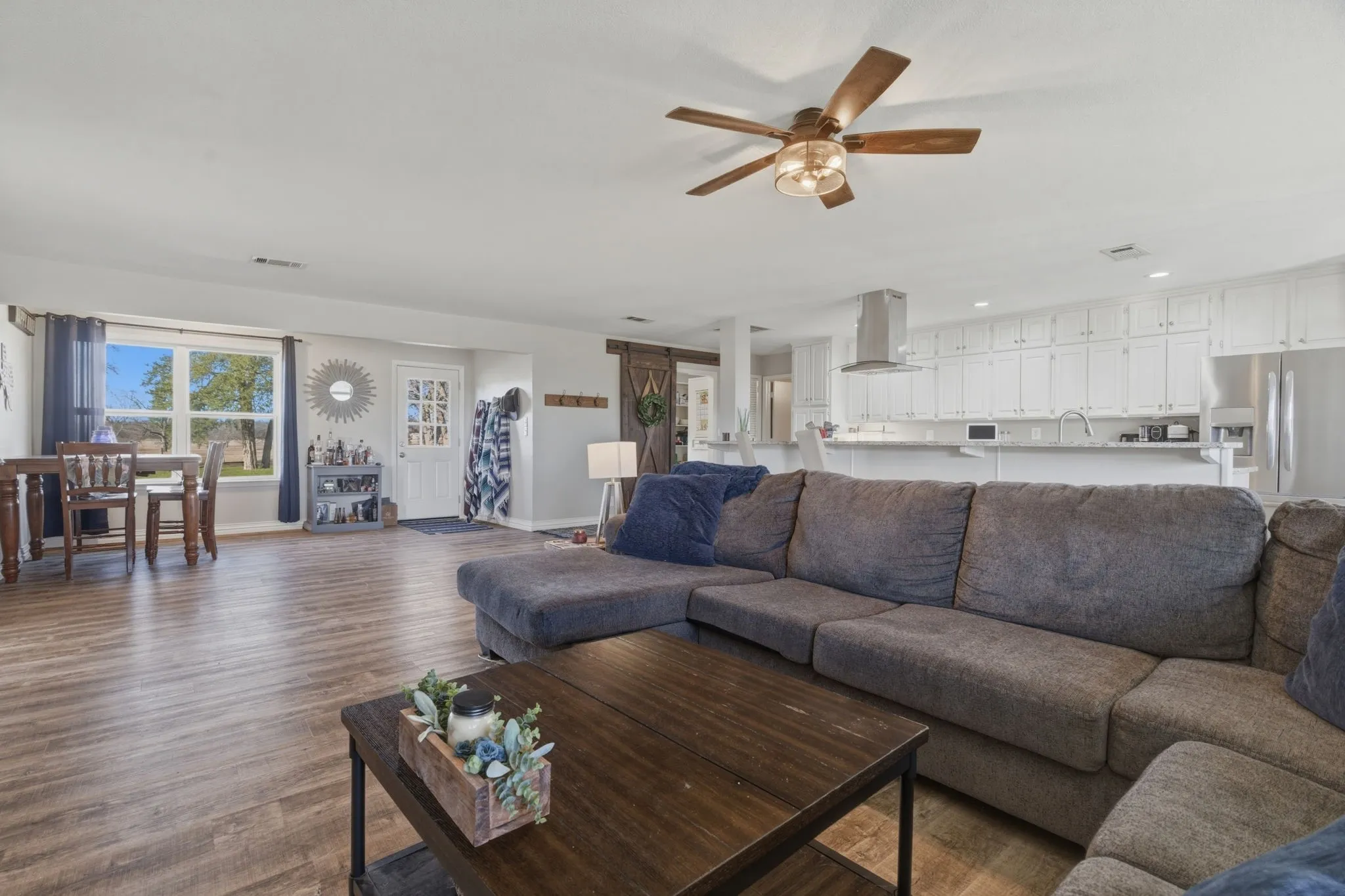 Living area featuring a ceiling fan, wood finished floors, and recessed lighting