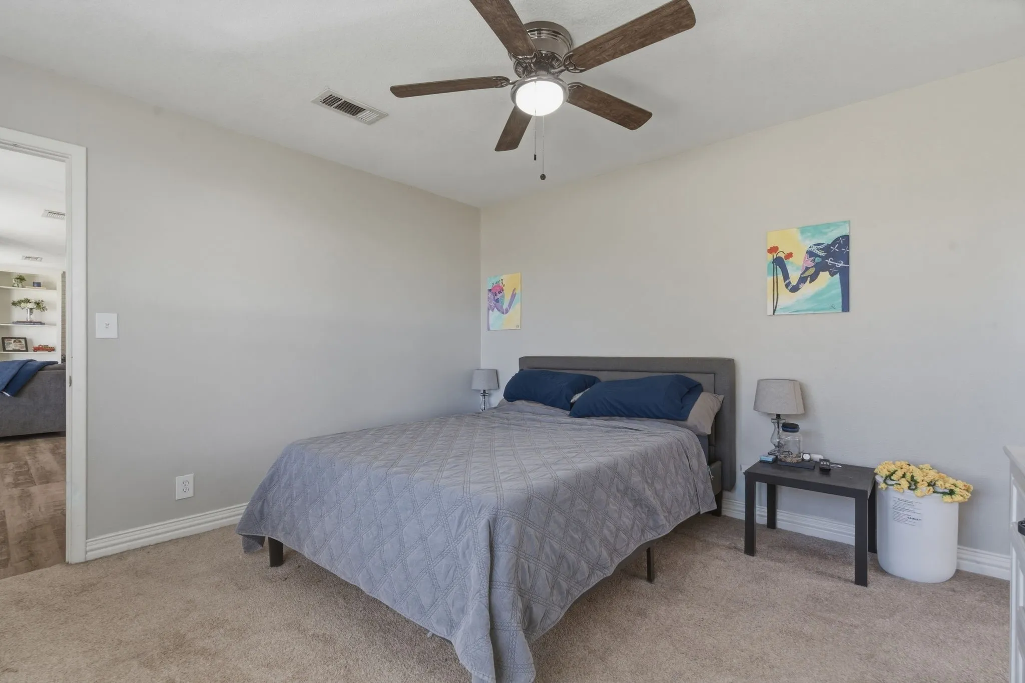 Bedroom with ceiling fan and light carpet
