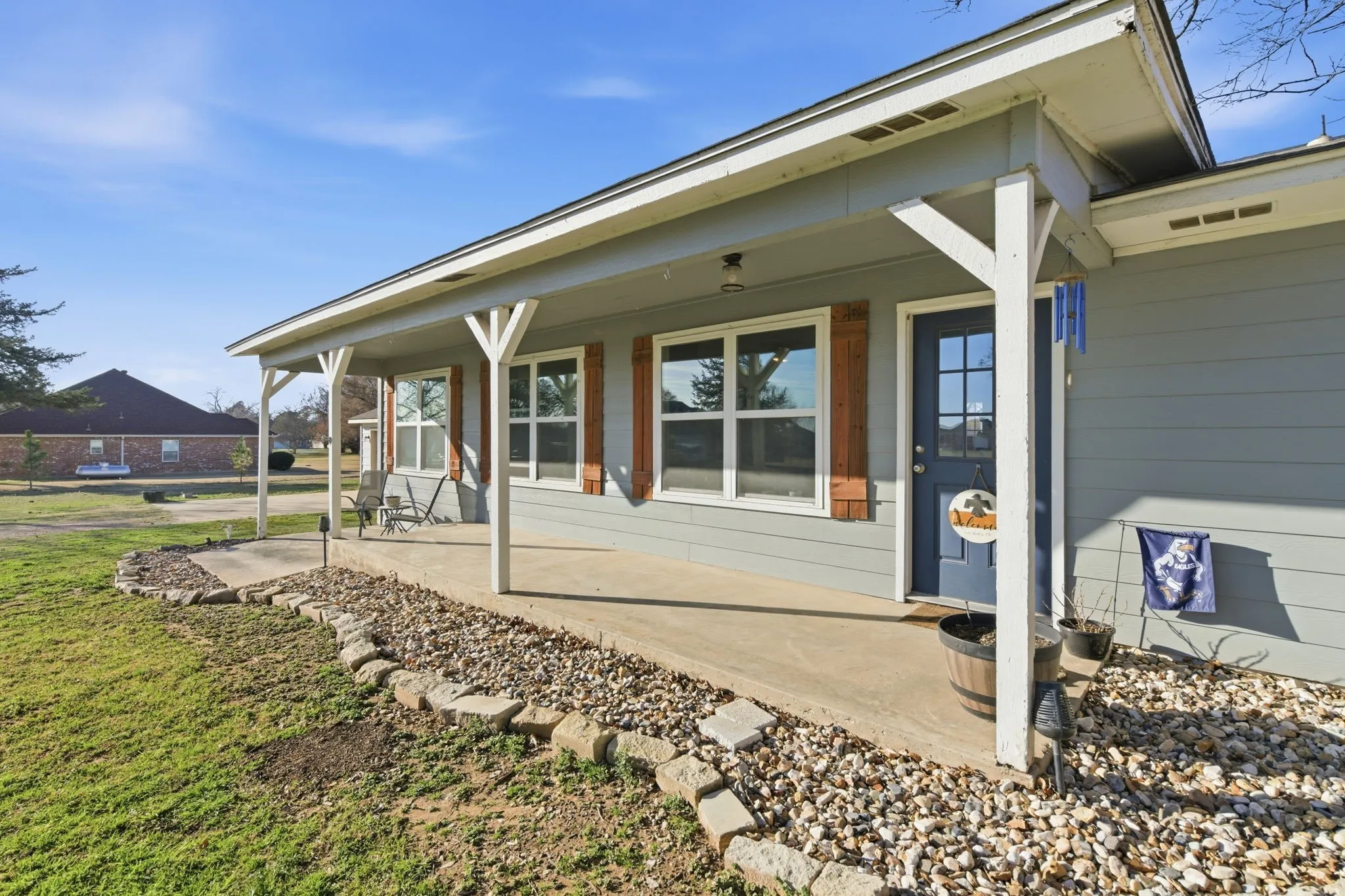 View of exterior entry with a porch and a yard