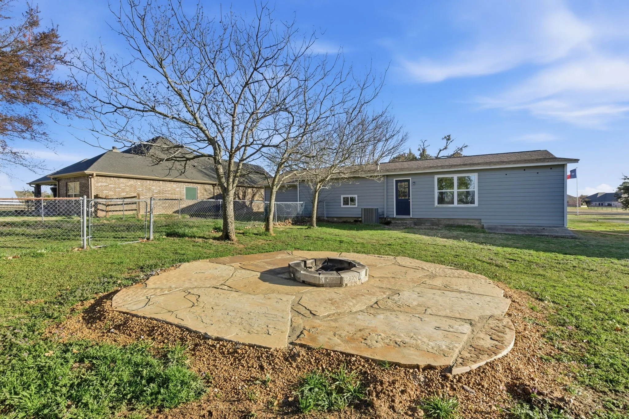 Rear view of house featuring a patio area, an outdoor fire pit, and a gate