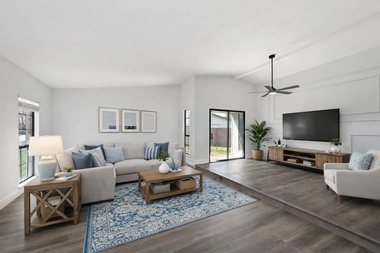 Living room featuring dark wood-type flooring, healthy amount of natural light, vaulted ceiling, and ceiling fan