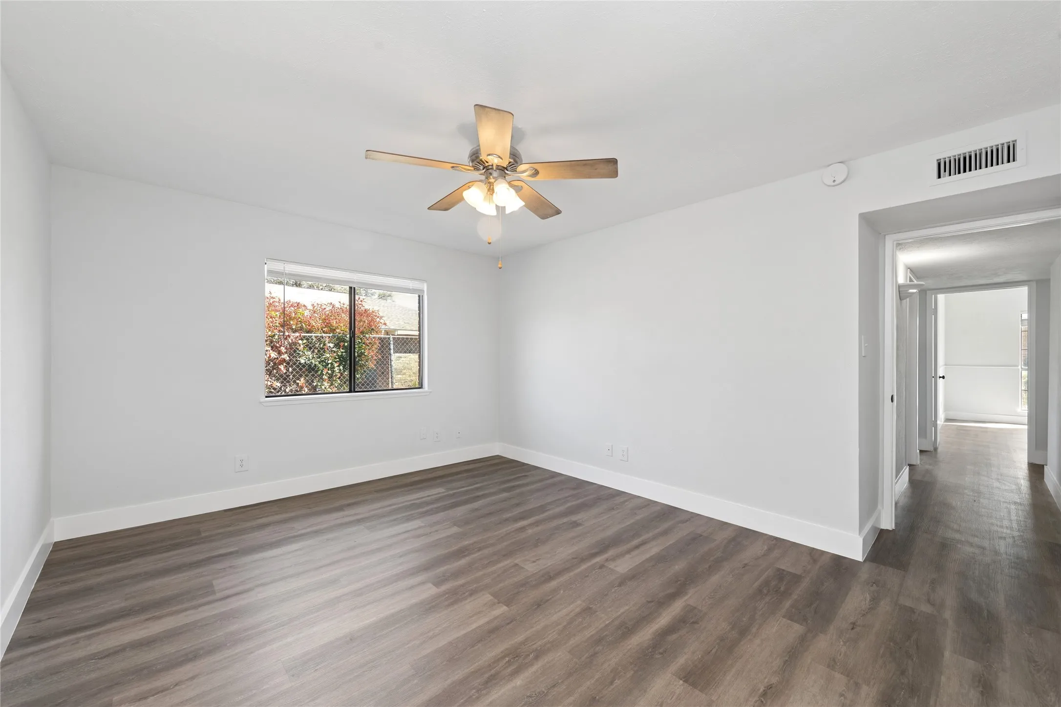 Spare room with ceiling fan and dark wood-style flooring