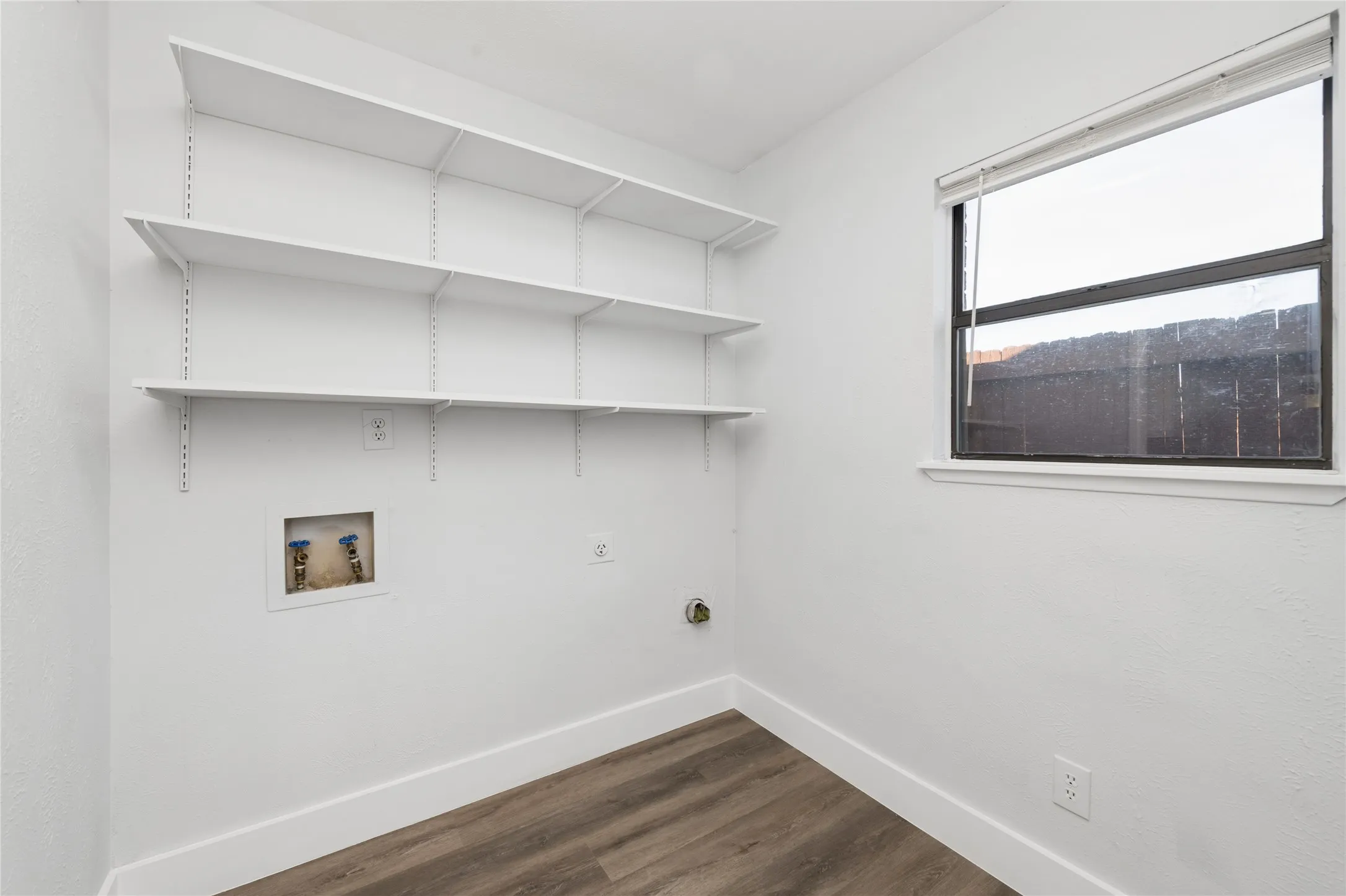 Laundry room featuring dark wood-style flooring, hookup for a washing machine, and hookup for an electric dryer
