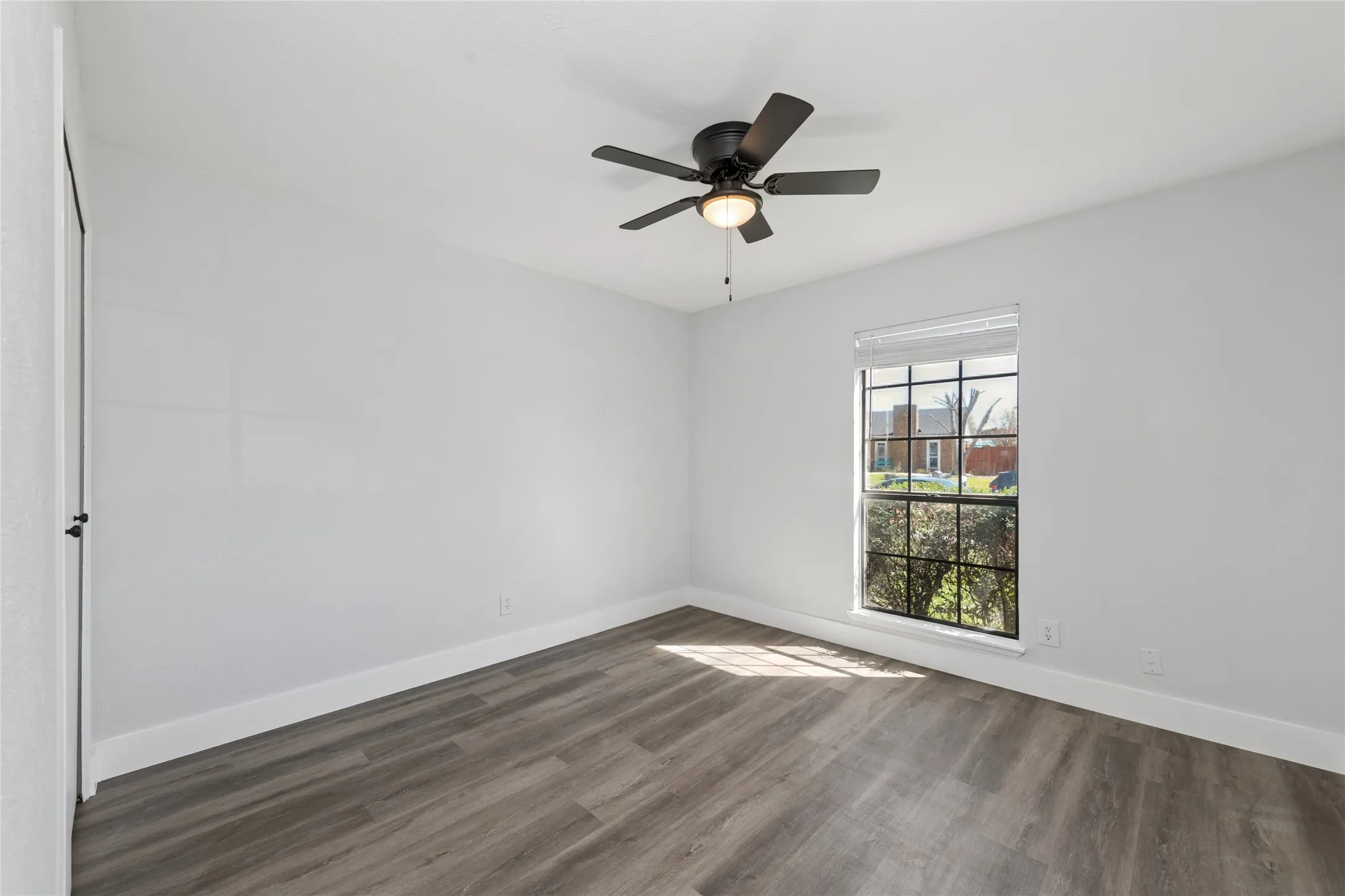 Spare room featuring dark wood finished floors and ceiling fan