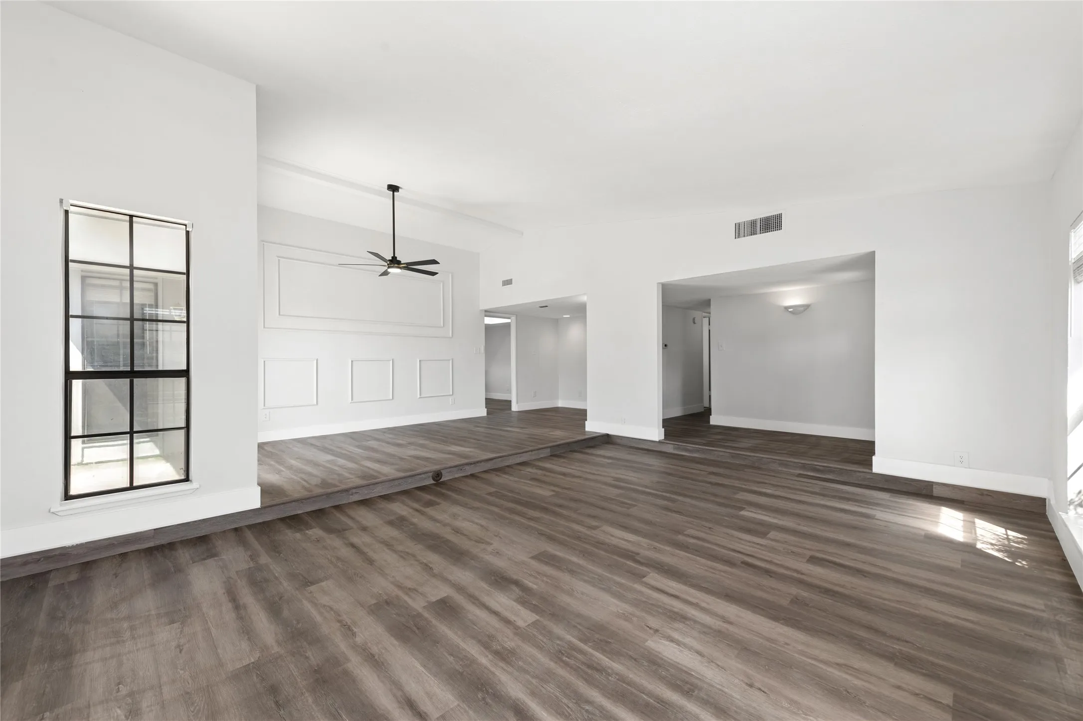 Unfurnished living room featuring dark wood finished floors and a ceiling fan