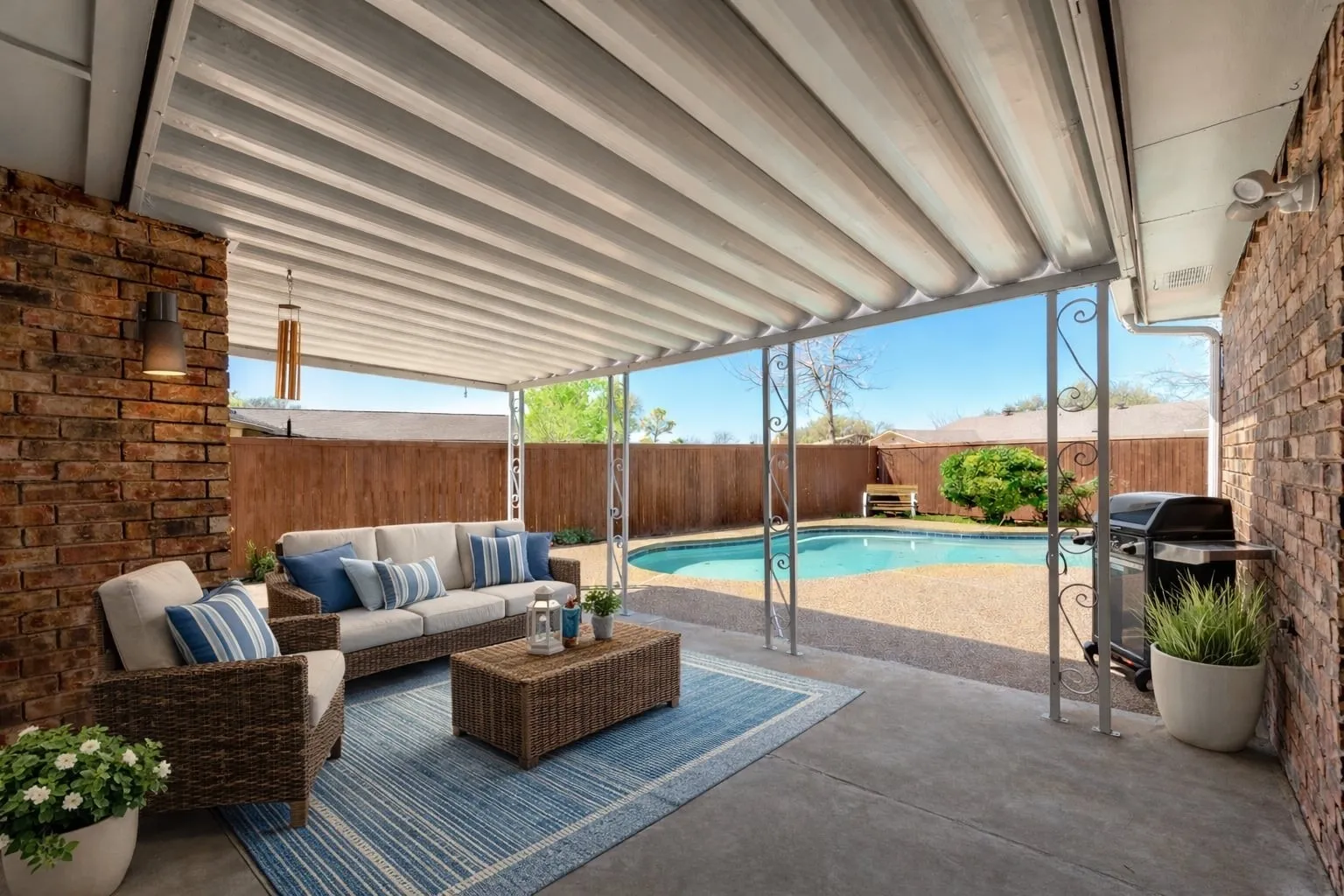 View of pool with patio surround, an outdoor lounge area, grilling area, and a fenced backyard
