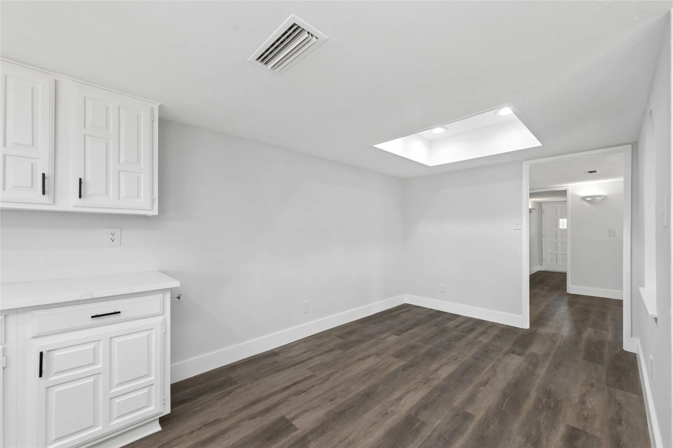 Unfurnished dining area with dark wood-type flooring and recessed lighting