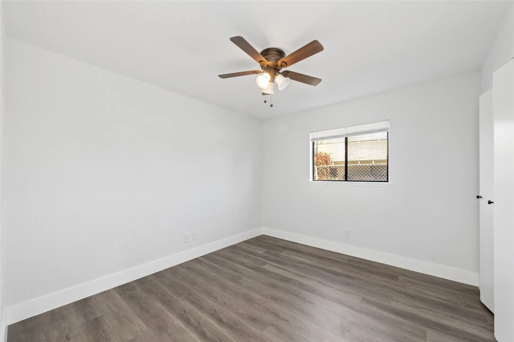 Unfurnished room with dark wood-style flooring and a ceiling fan