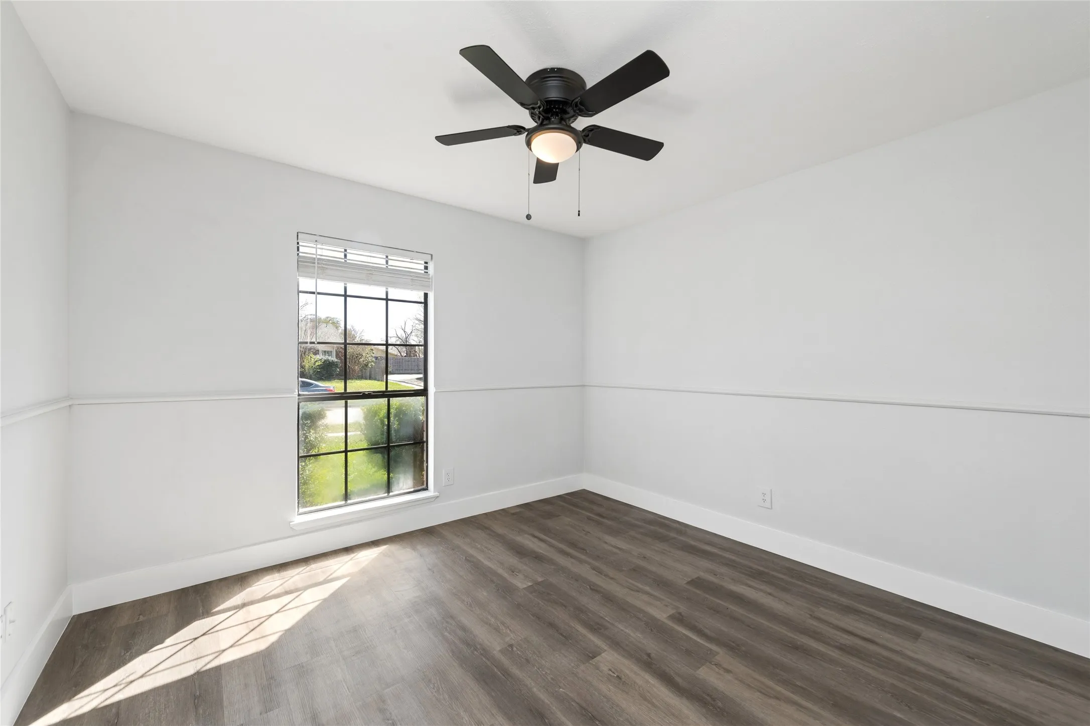 Spare room featuring a ceiling fan and dark wood-style floors