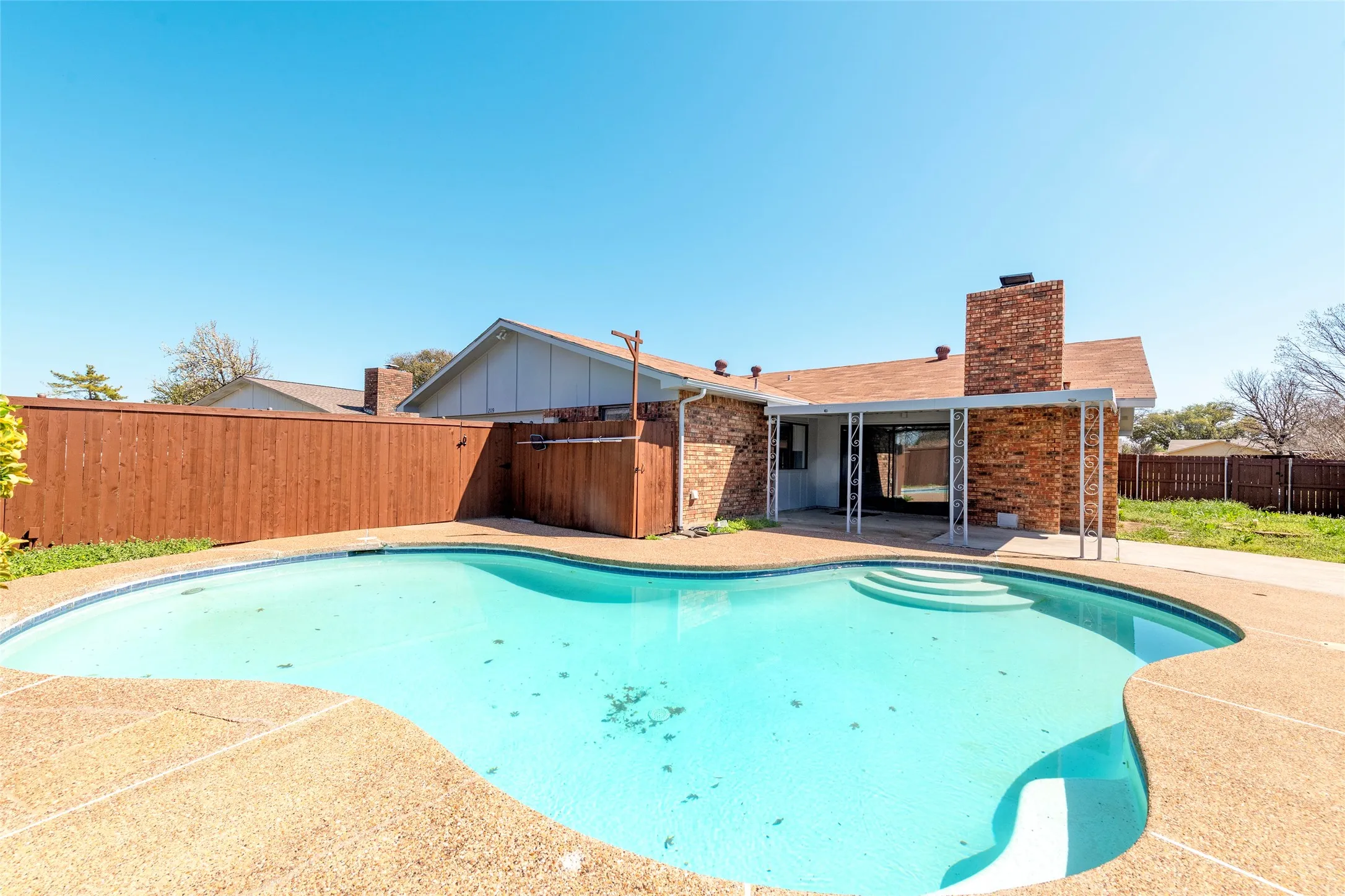 View of pool featuring patio surround and a fenced backyard
