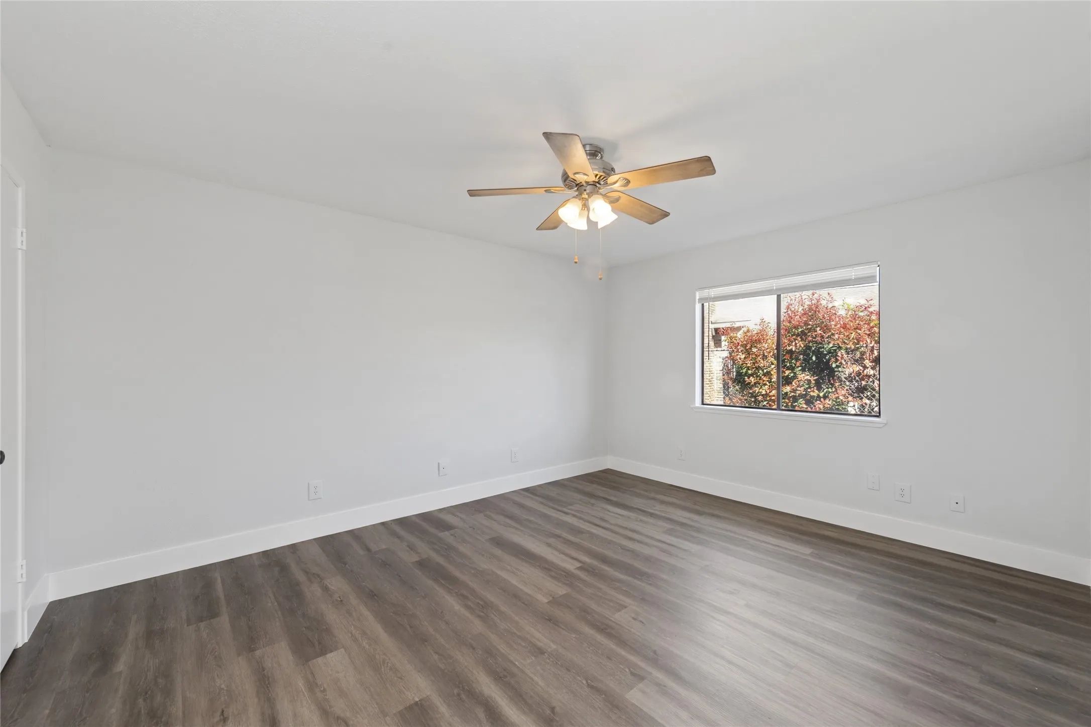 Unfurnished room featuring dark wood-type flooring and a ceiling fan
