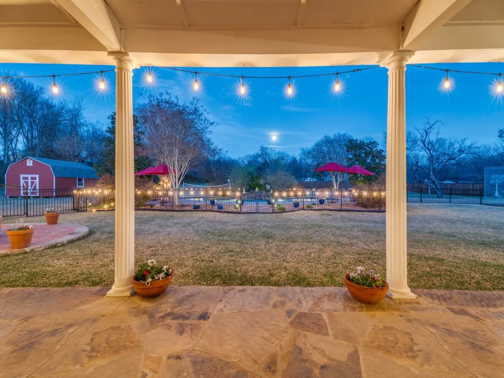 View from the beautiful covered flagstone patio looking toward the swimming pool and barn.
