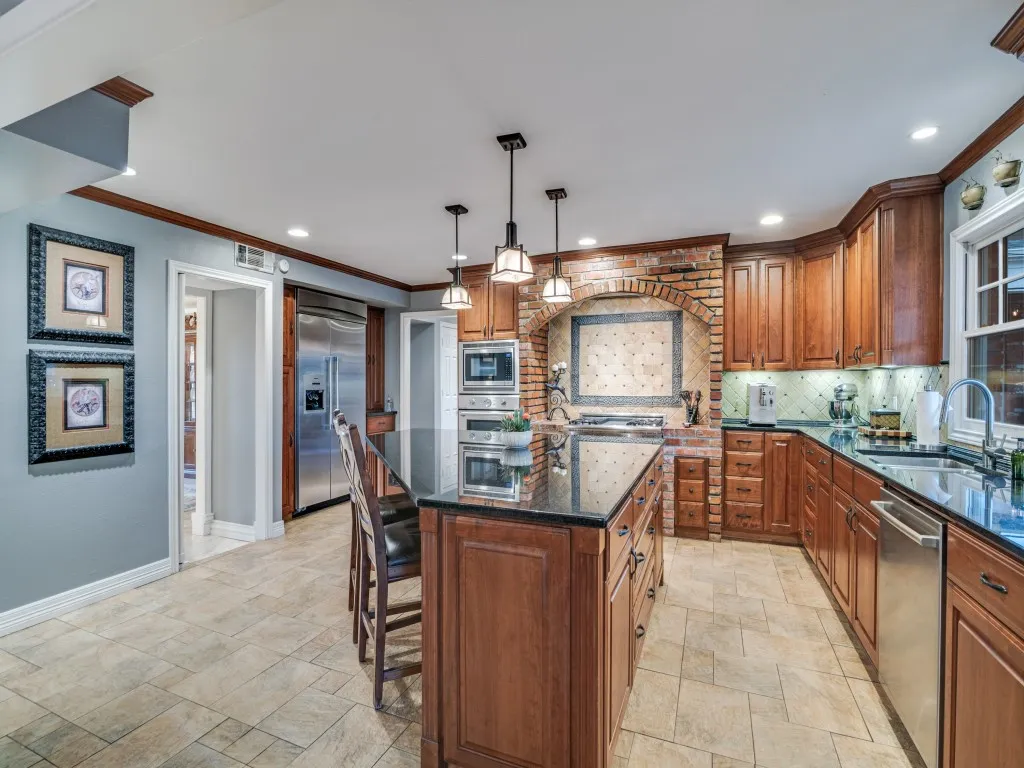 Updated tile flooring, under cabinet lighting, window over the sink and built-in refrigerator.  31 shelves of pantry space in the hallway!