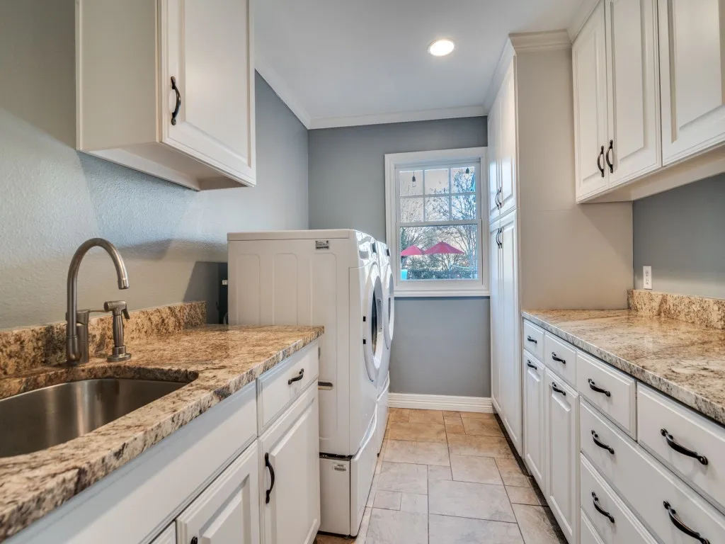 Extra large utility room with granite countertops, lots of built-ins and sink.