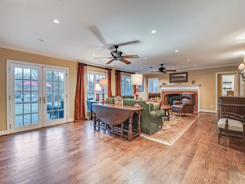 This main living area with expansive views of the back yard features wood floors and a huge brick fireplace with gas logs.