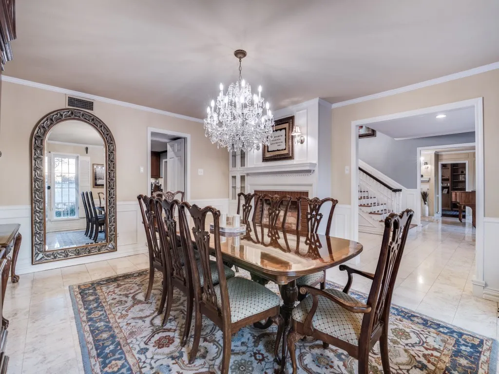 The oversized dining area boasts a decorative chandelier, built in storage and a faux fireplace.