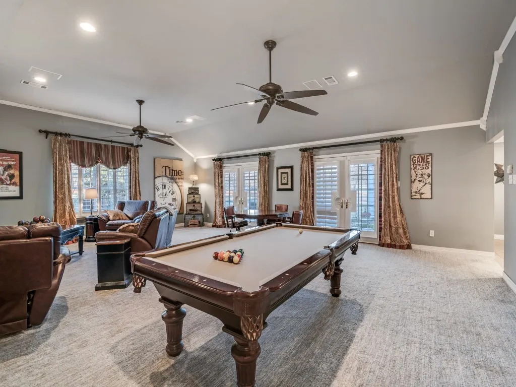 Game room has floor to ceiling windows with access to the back patio.