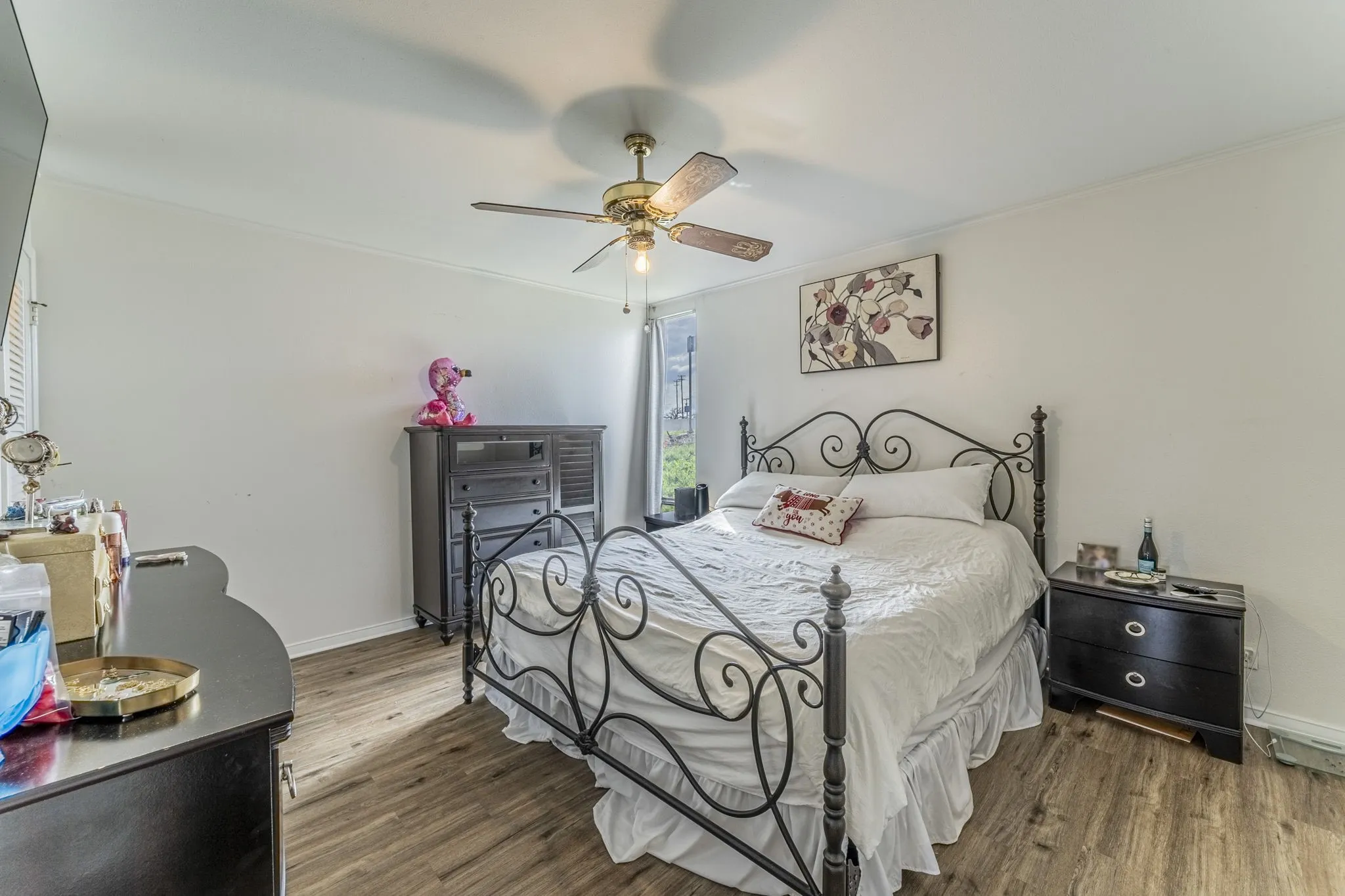 Spacious primary bedroom with neutral colors and beautiful flooring.