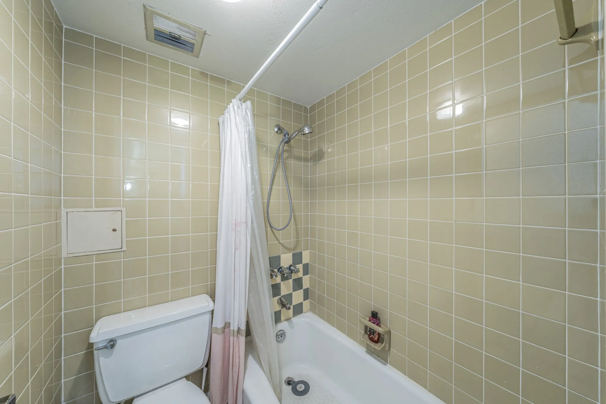 Second ensuite bath featuring neutral tile walls.