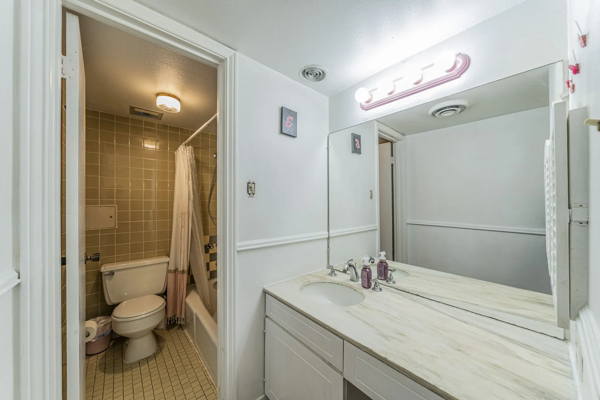 Second primary bath features a granite vanity and plenty of storage.