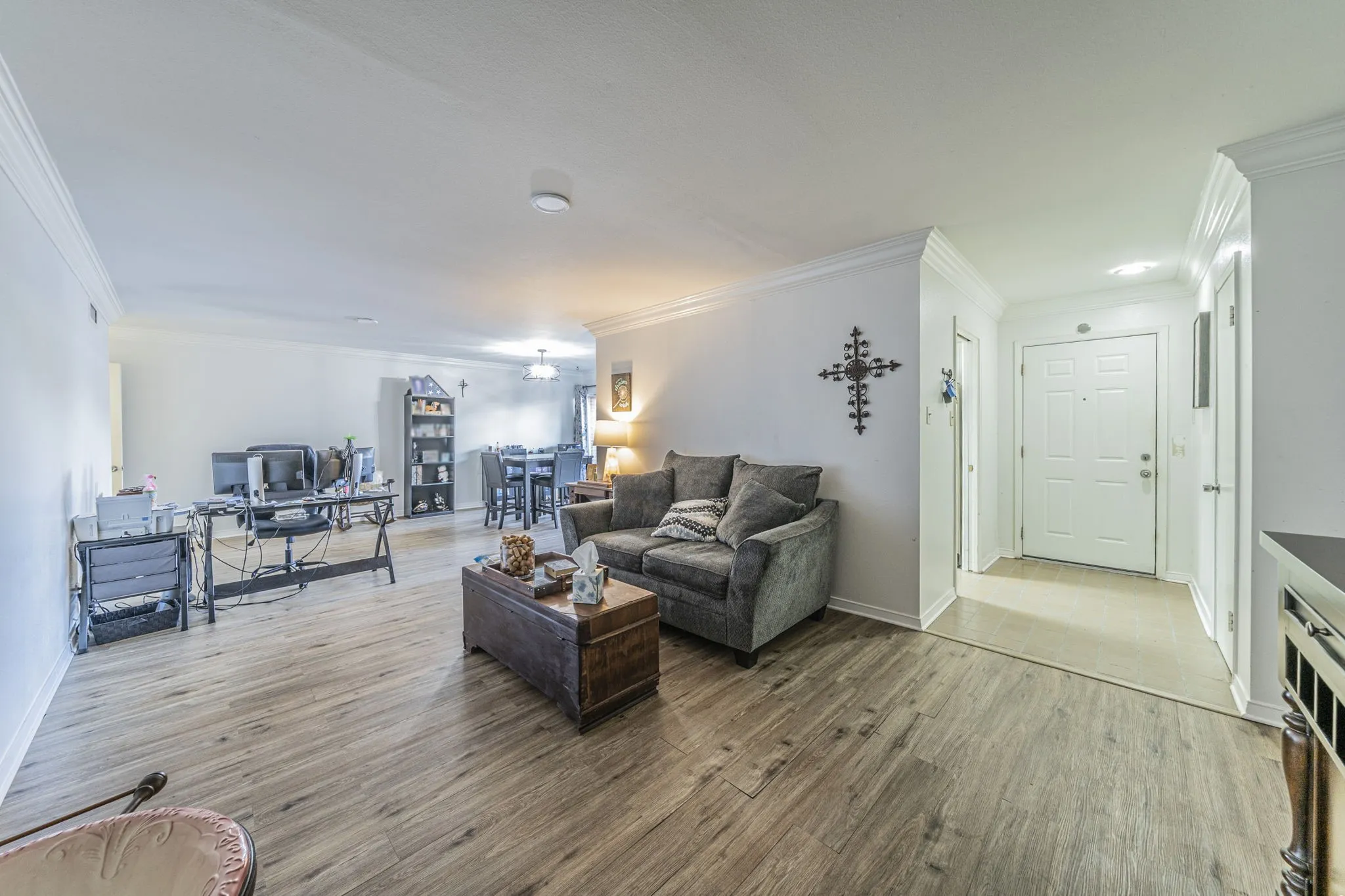 Open concept living room features crown molding and neutral colors.