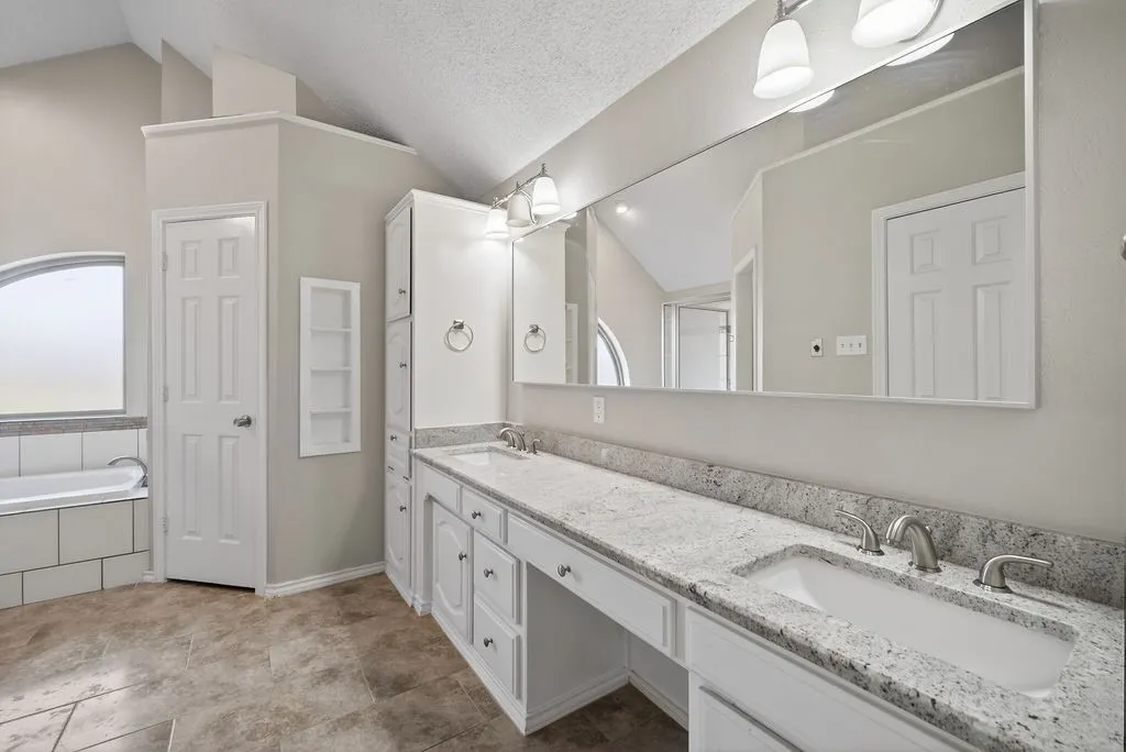 Full bathroom featuring double vanity, a bath, and a shower stall