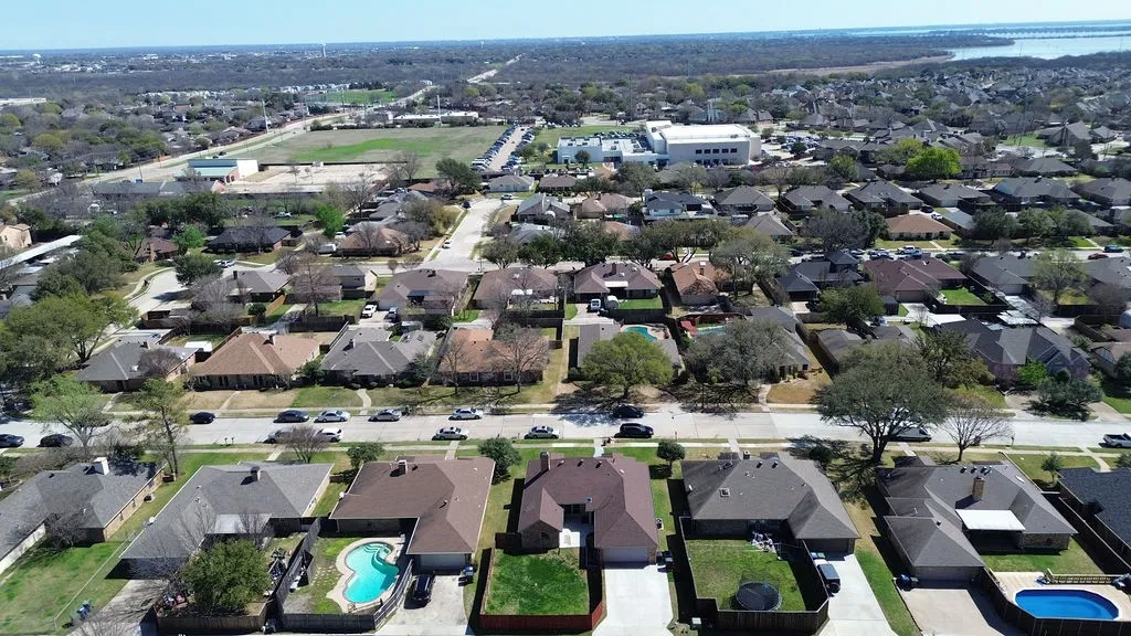 Aerial view of property's location with a pool area and nearby suburban area