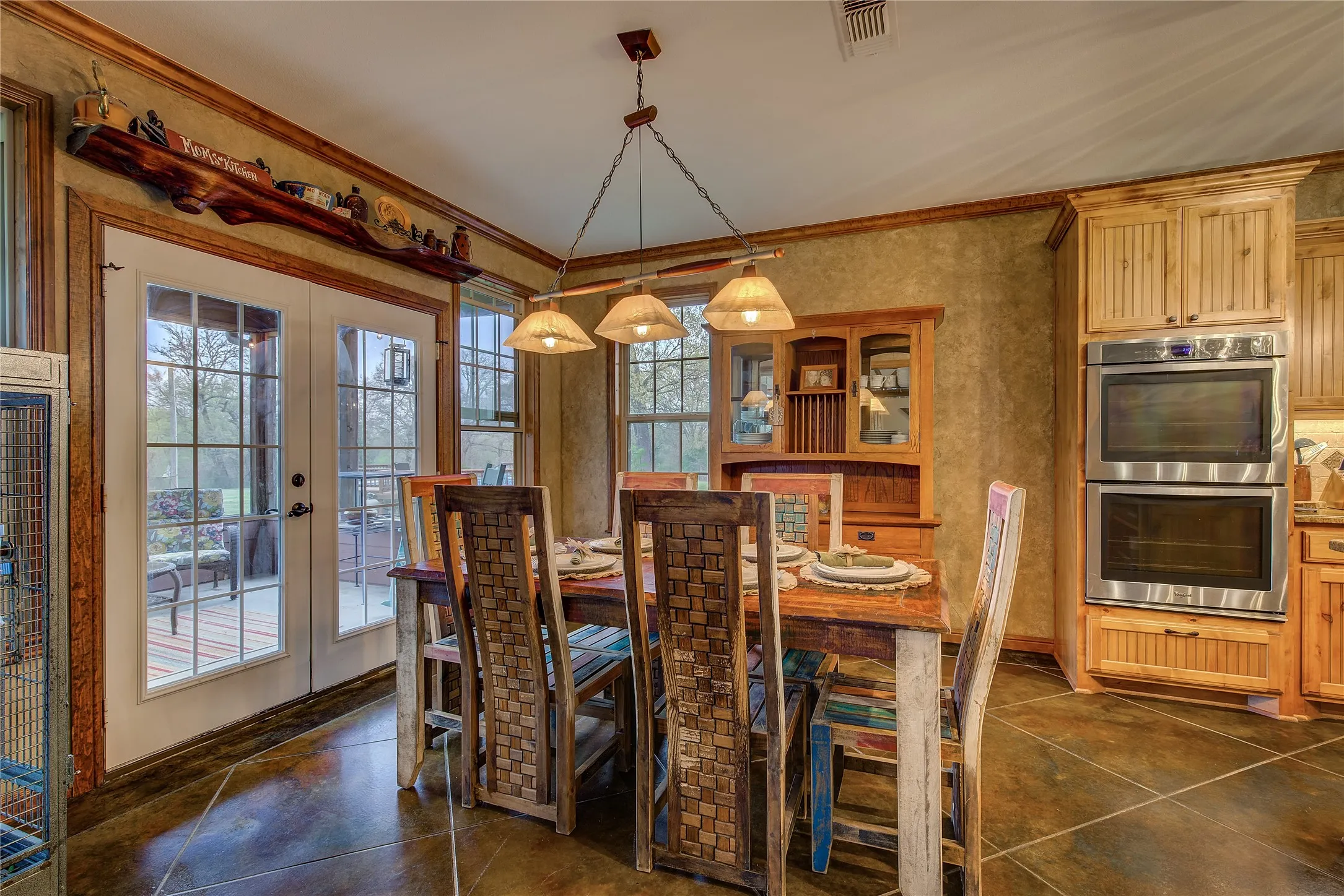 Gourmet eat-in kitchen measuring 23’5” x 14’3”, featuring a large island, double ovens, cooktop, appliance garage, breakfast bar, and custom upgrades throughout.