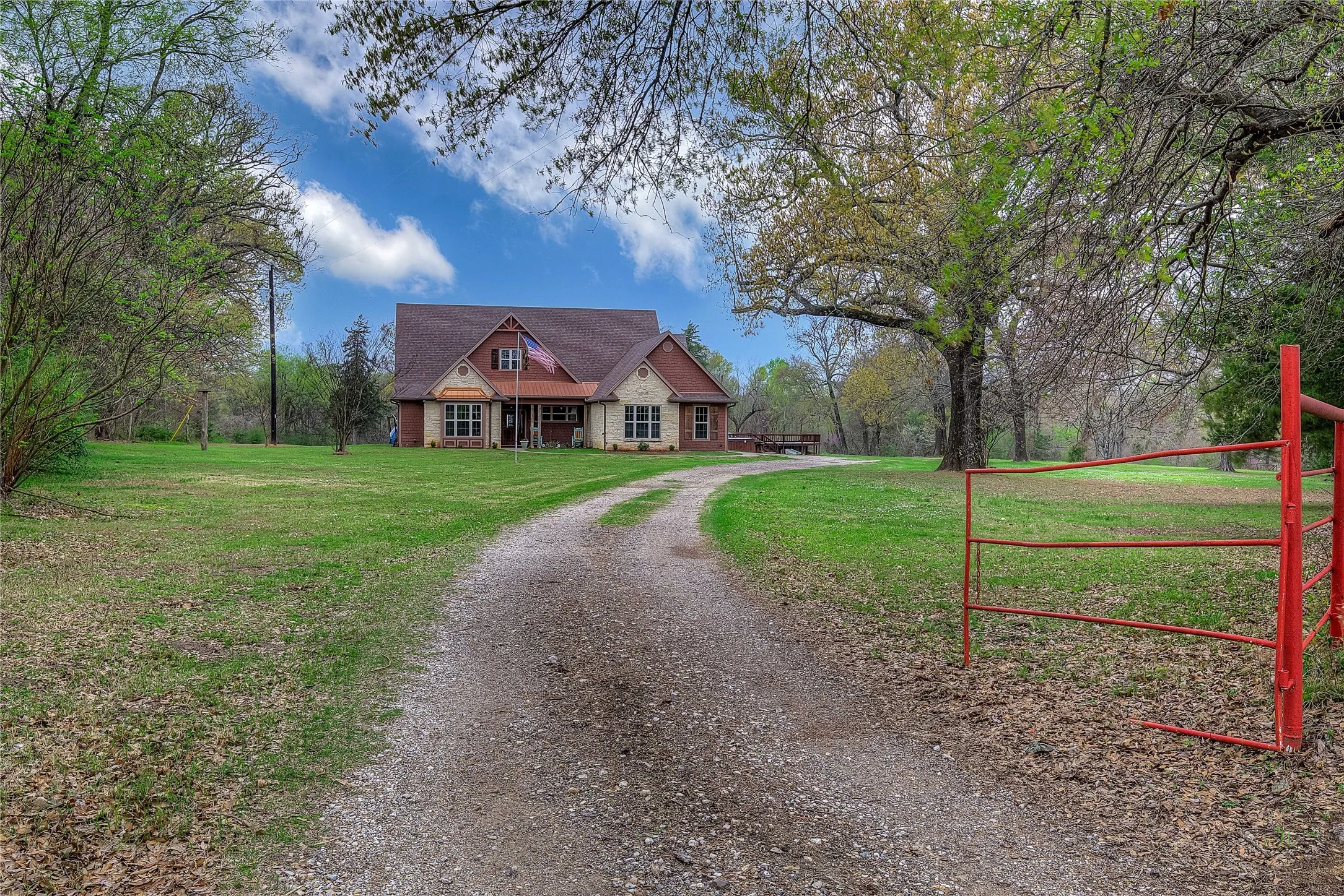 Secluded home nestled among mature trees and rolling green space.