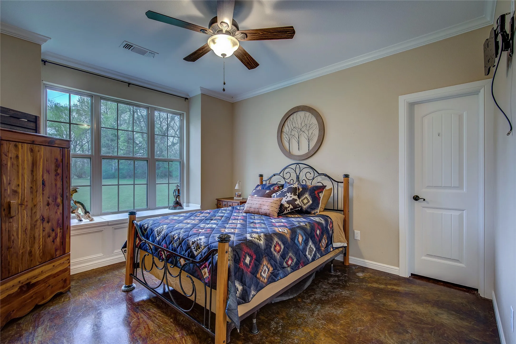 Second bedroom measuring 13’10” x 12’, featuring a walk-in closet, charming window seat, and updated stained concrete flooring.