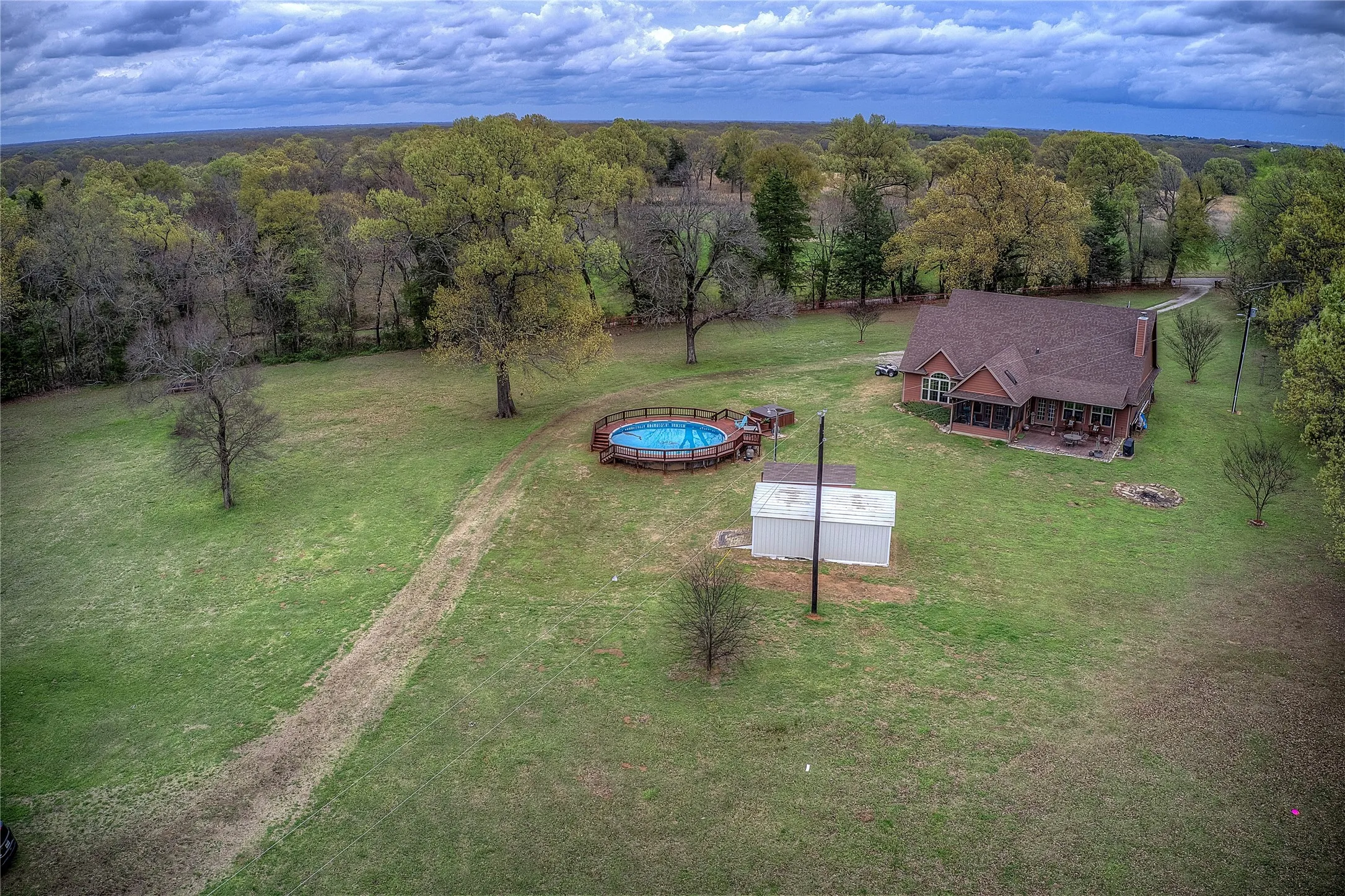Private country retreat with multiple storage sheds, an above-ground pool with new decking, hot tub, and a private RV hookup with its own septic and electric meter.