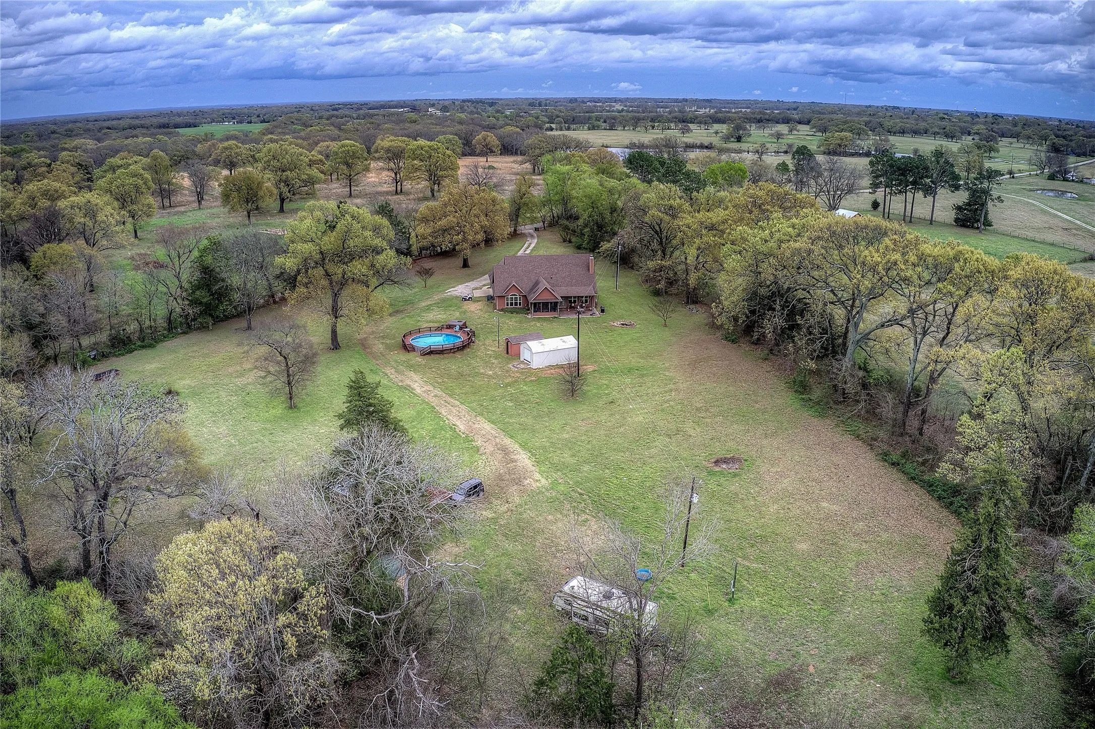 Private country retreat with multiple storage sheds, an above-ground pool with new decking, hot tub, and a private RV hookup with its own septic and electric meter.