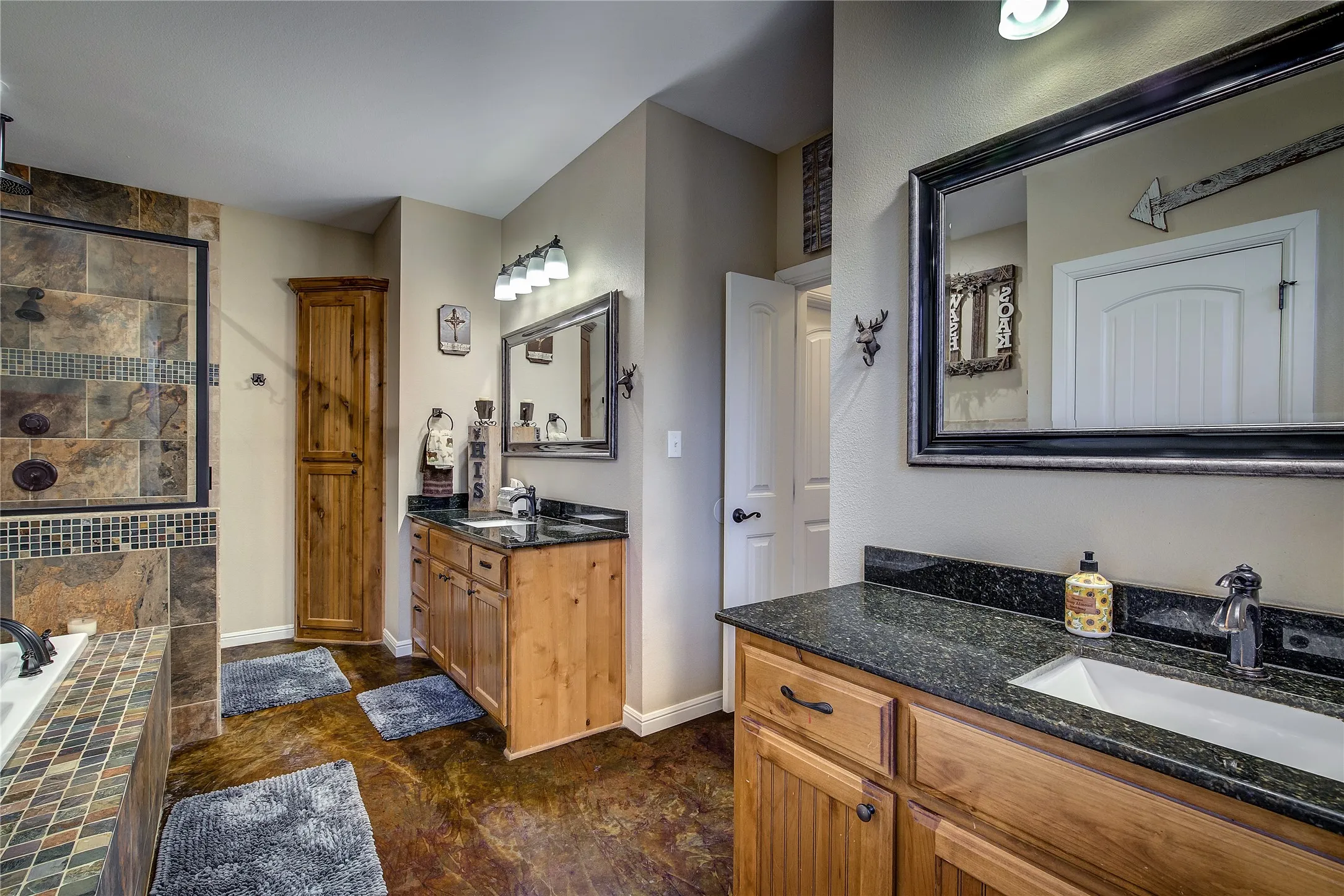 En suite bathroom measuring 17’6” x 12’2”, featuring dual vanities, a garden tub, linen closet, separate custom shower with rainfall showerhead, and his-and-hers walk-in closets.