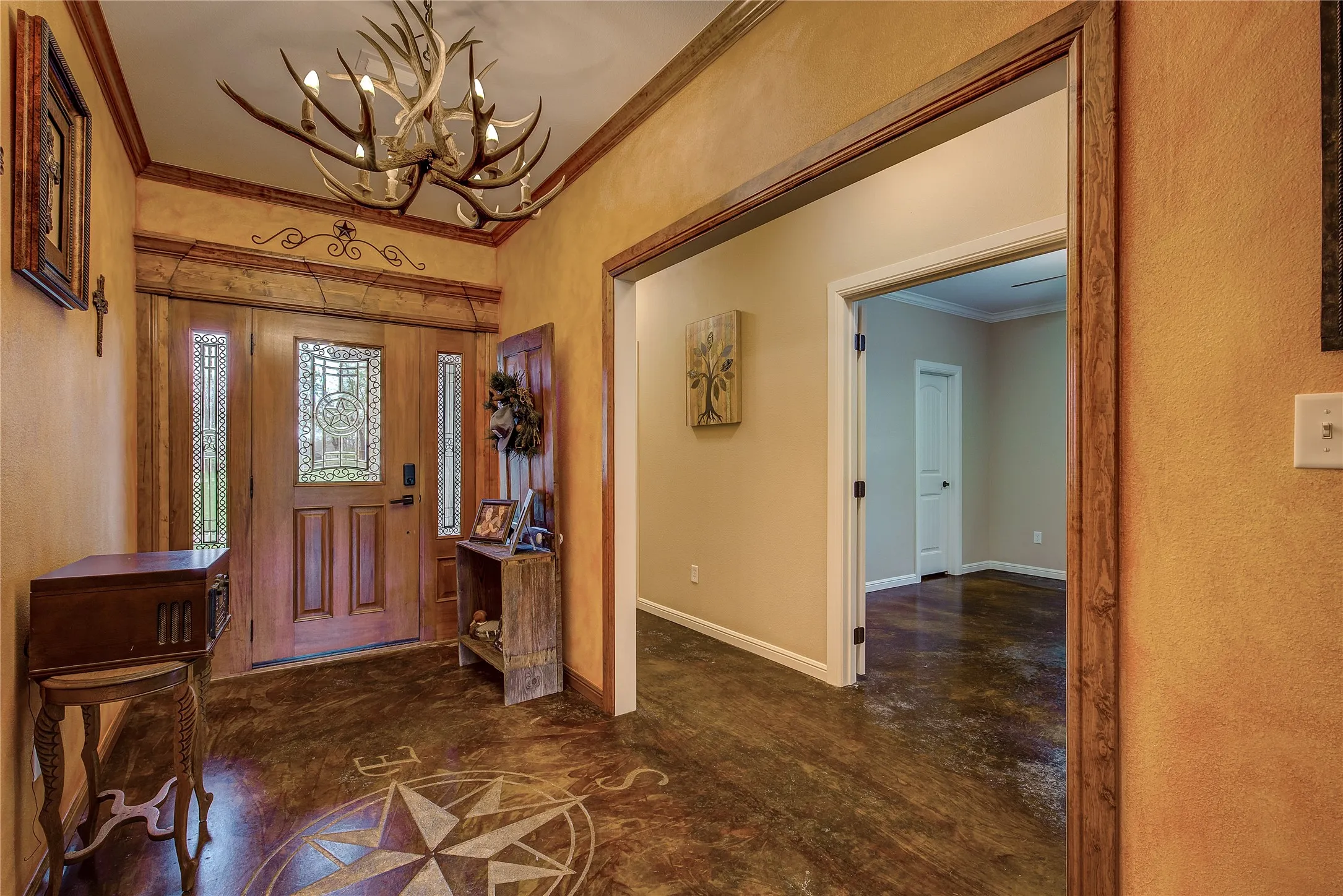 Large grand entryway featuring custom concrete flooring and decorative lighting.