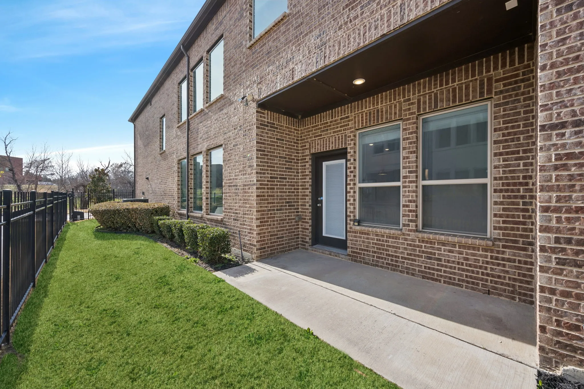Property entrance with brick siding and a patio area