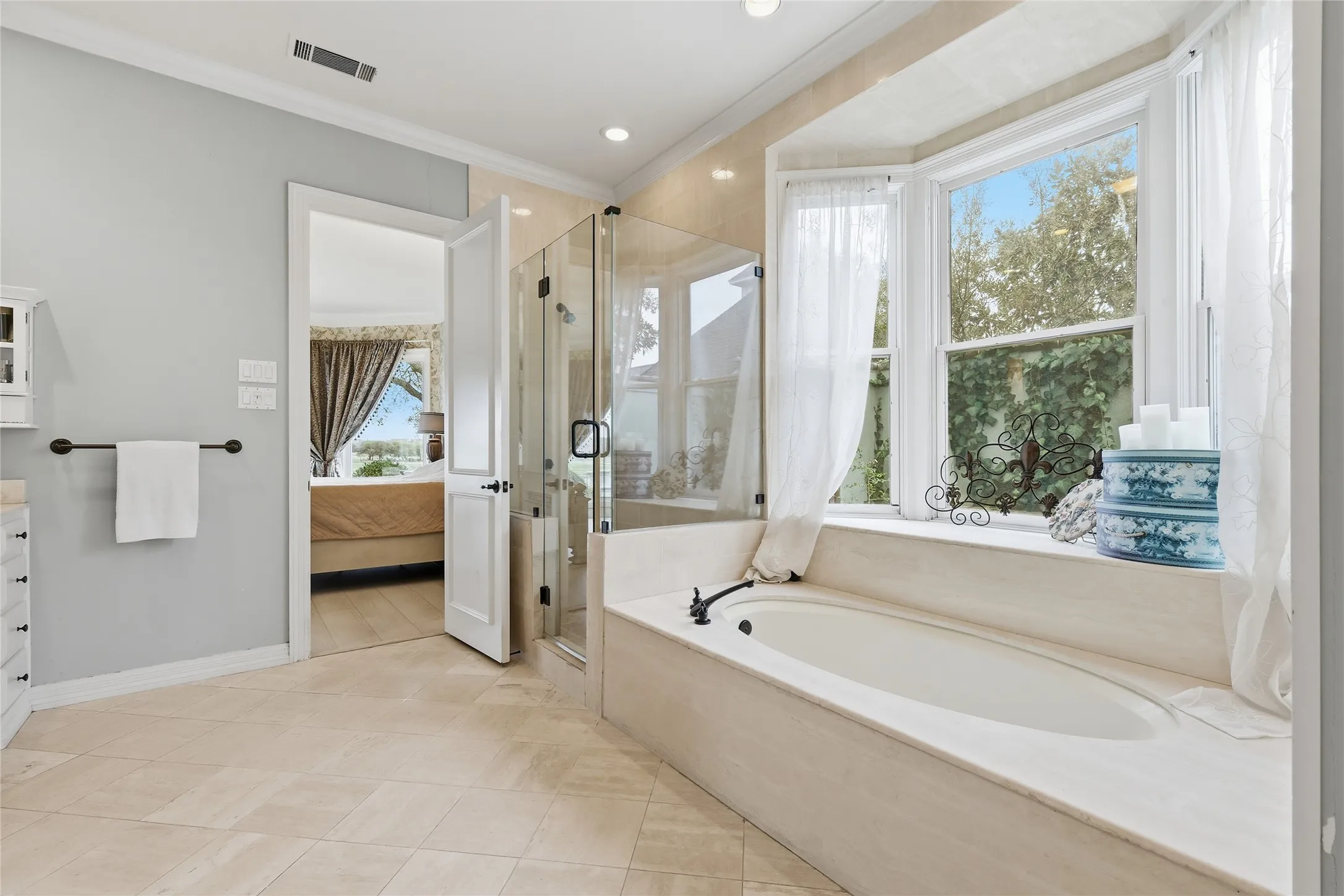 Ensuite bathroom featuring a stall shower, ornamental molding, vanity, a garden tub, and recessed lighting
